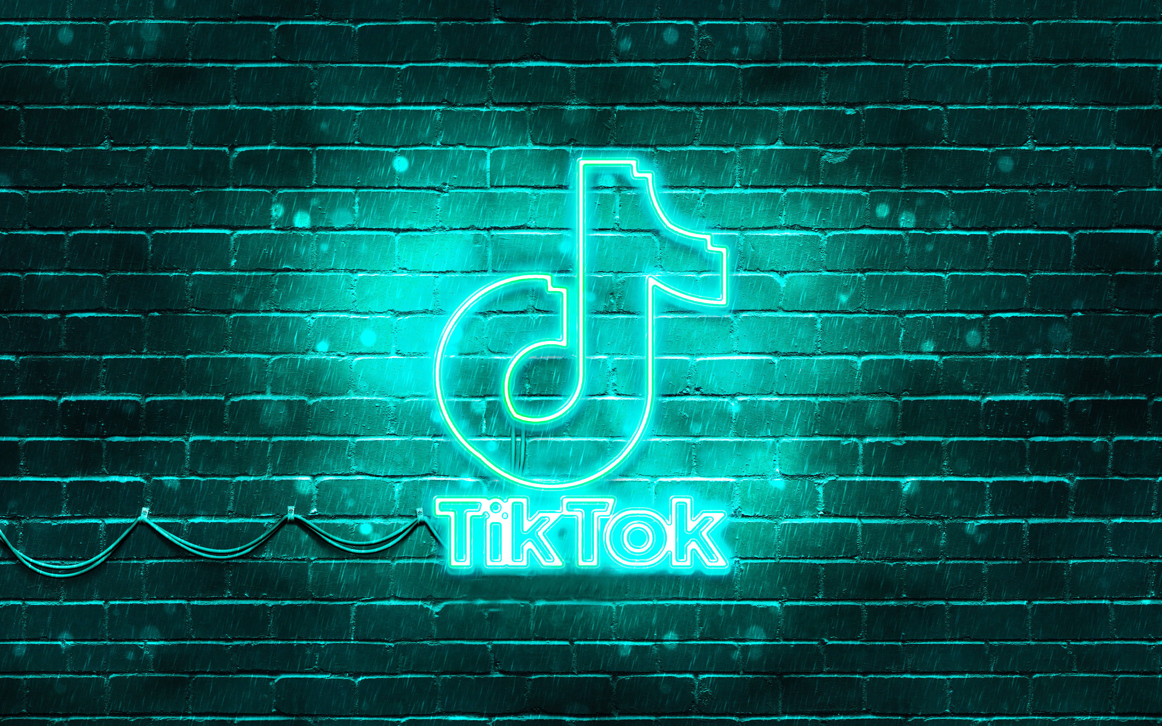 TikTok 動圖 桌布 壁紙 — 一個發光的青綠色霓虹TikTok標誌在雨中照亮濕磚牆。