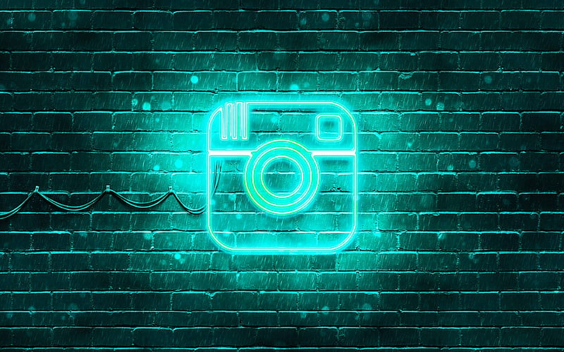 Instagram 桌布 壁紙 — 一個發光的青色霓虹燈Instagram標誌在夜雨中閃耀在濕磚牆上。