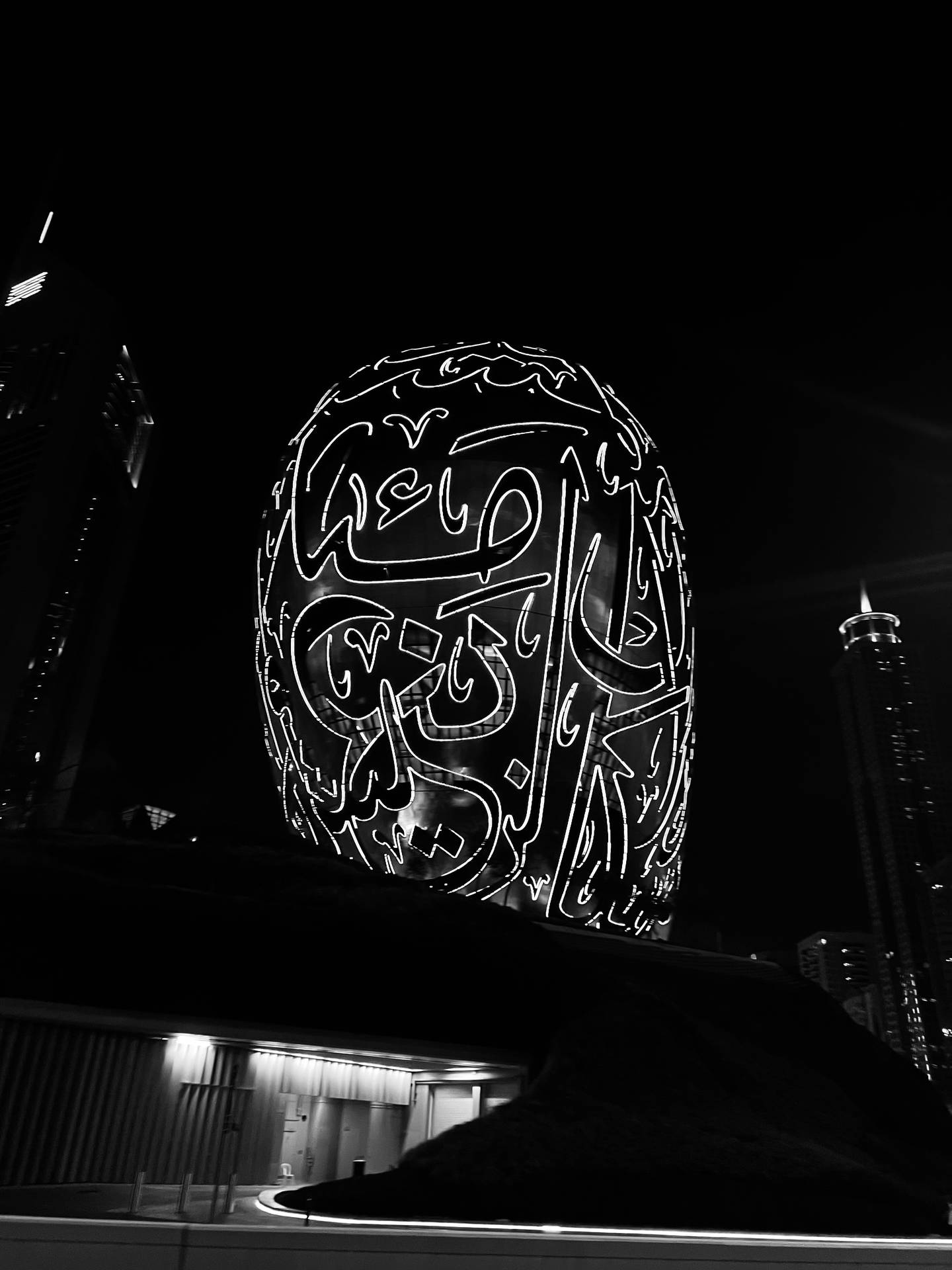 夜晚城市中帶有阿拉伯書法的發光頭骨雕塑。 — 旅行 GIF 壁紙