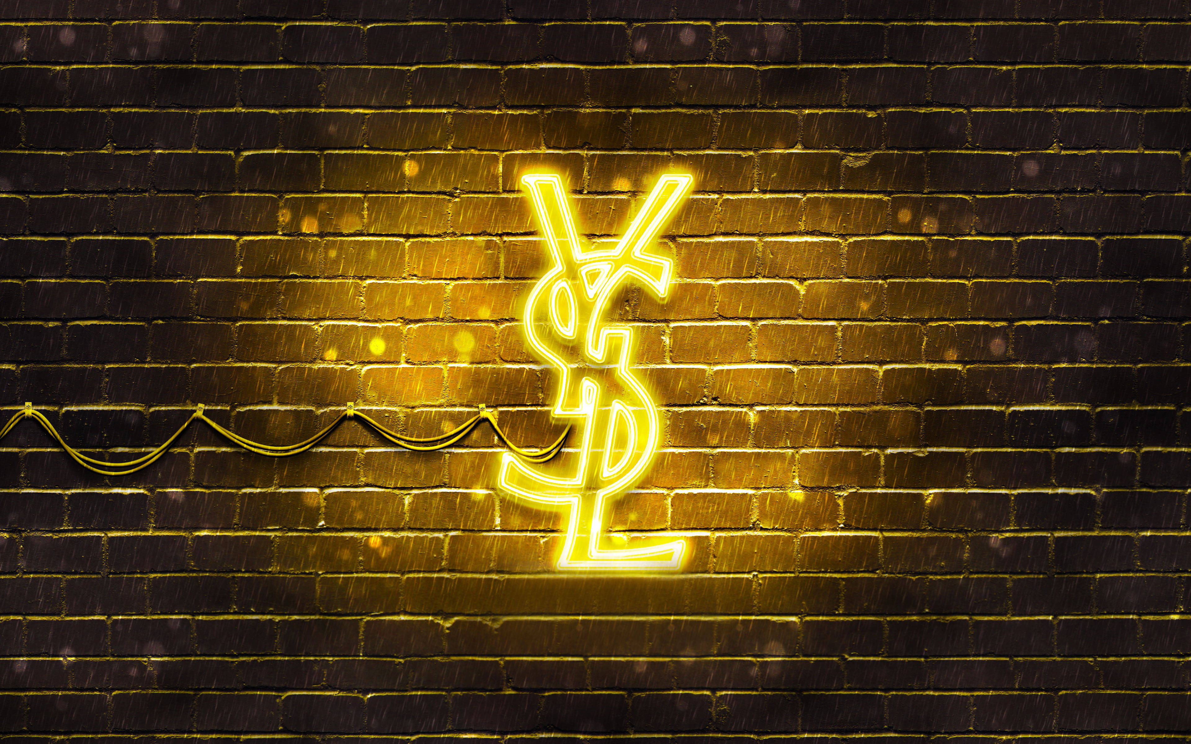 Ysl 桌布 壁紙 — 一個發光的黃色YSL霓虹燈牌在夜雨中對著濕暗的磚牆閃爍。