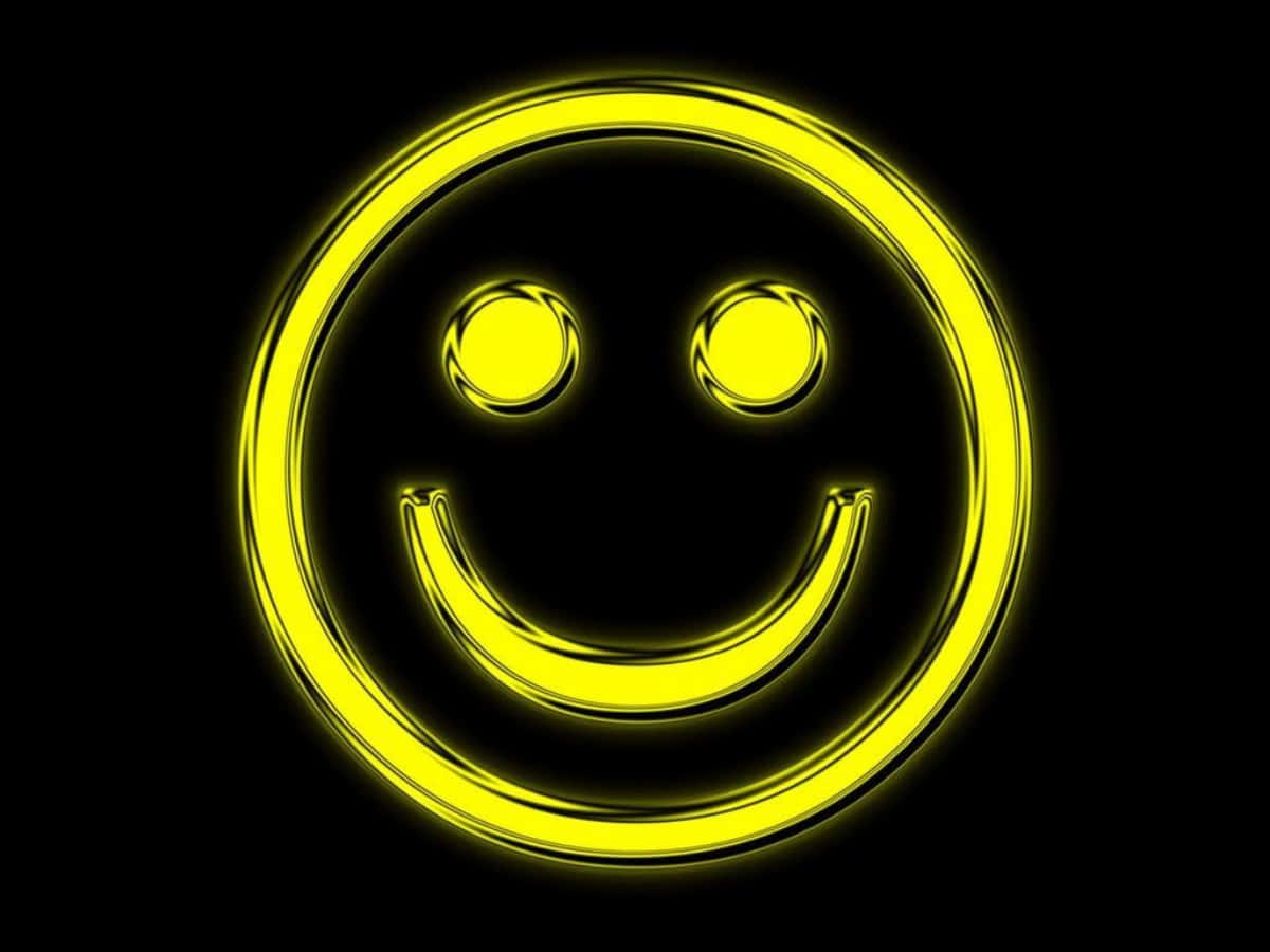 Smiley 桌布 壁紙 — 一個發光的黃色笑臉，帶有明亮的光環，在純黑色背景上散發出歡樂的氣息。
