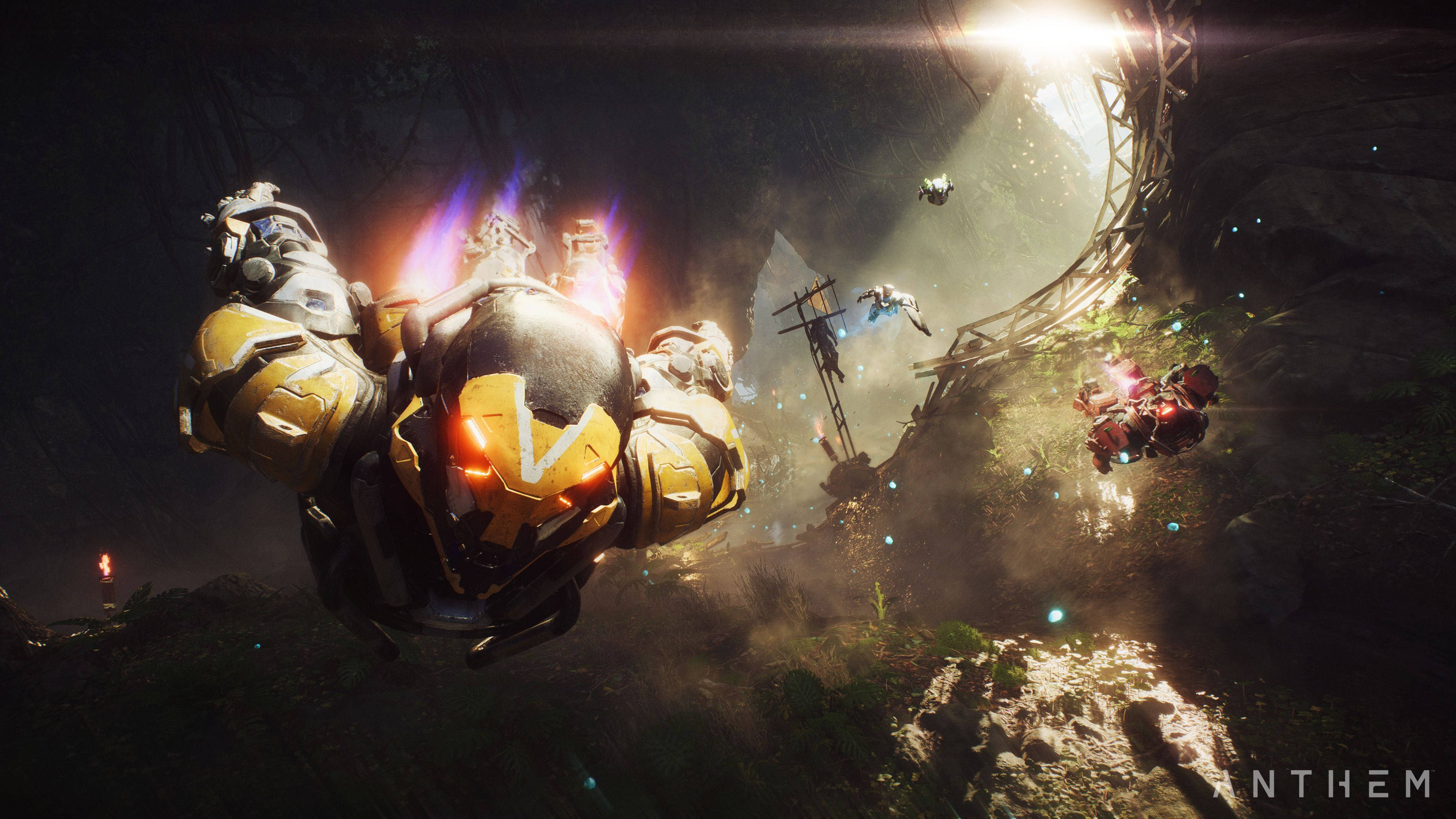 anthem 4K 桌布 壁紙 — 一個發光的黃色裝甲身影在黑暗的森林峽谷中翱翔，光束穿透霧氣瀰漫的空氣。