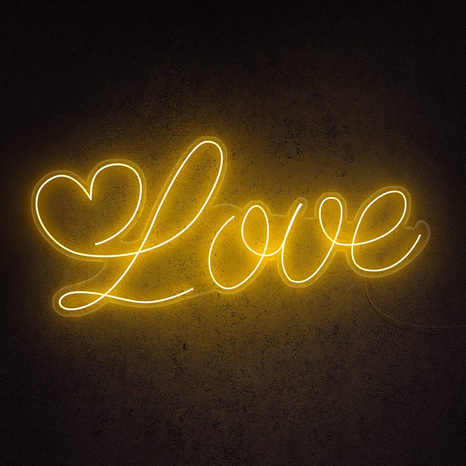 螢光黃 桌布 壁紙 — 一個發光的黃色霓虹燈牌，拼出 'Love'，其中 'L' 被心形取代，背景是深色紋理牆壁。