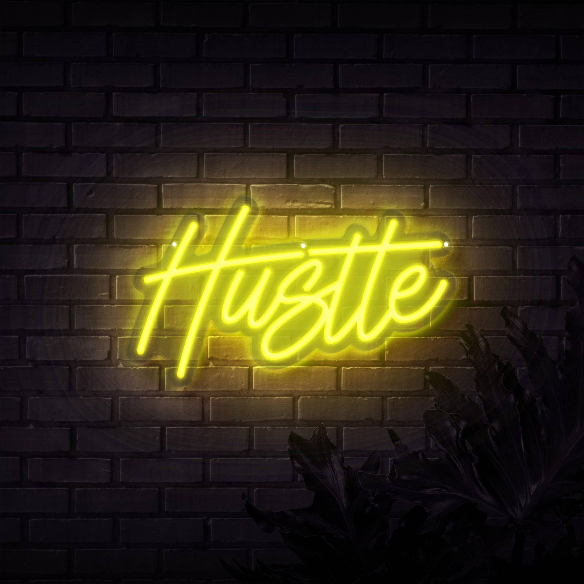 螢光黃 桌布 壁紙 — 一個發光的黃色霓虹燈牌，拼寫著「Hustle」，照亮了深色磚牆，下方有剪影葉子。