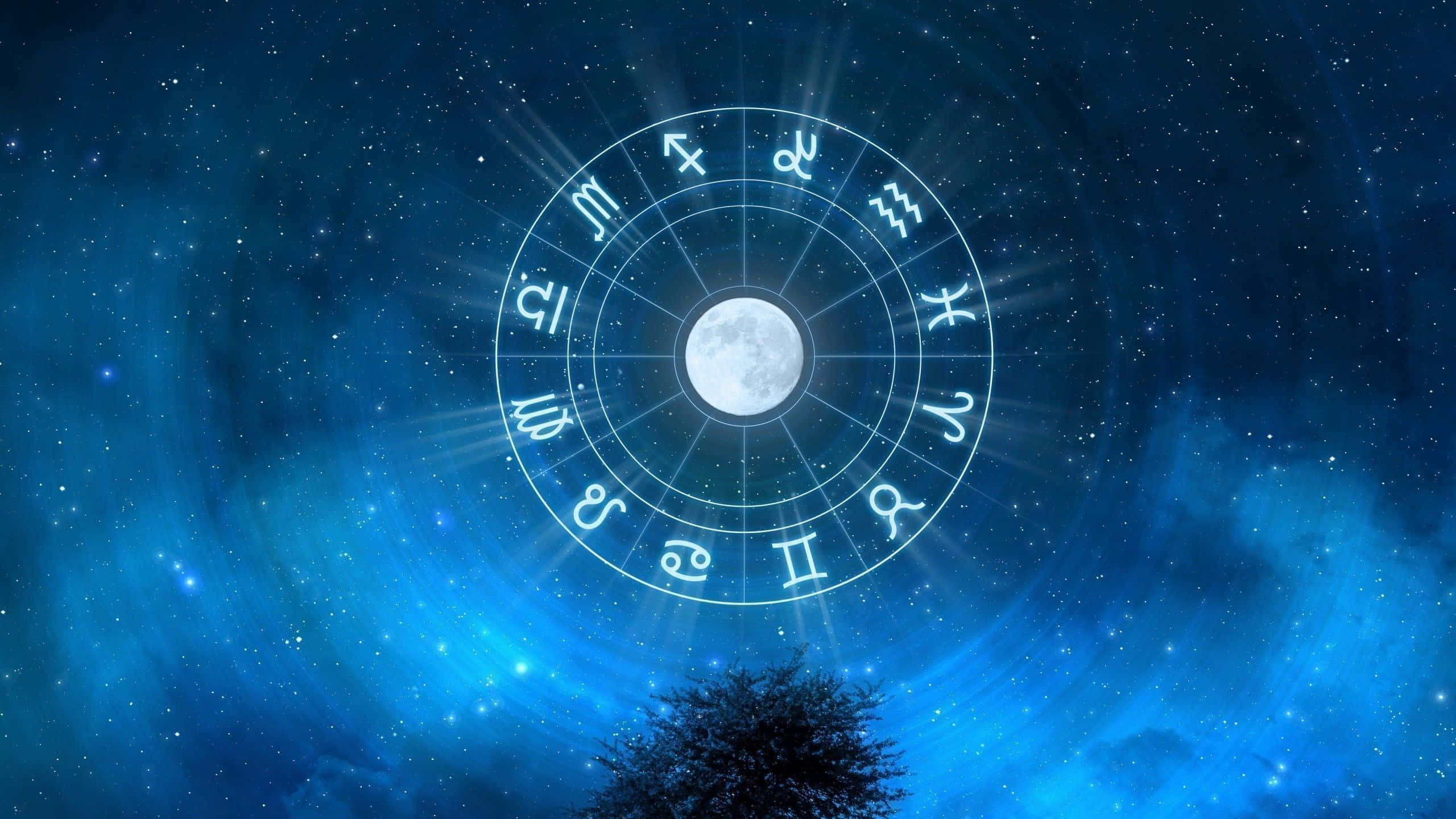 astrology 桌布 壁紙 — 一個發光的黃道輪，中心有月亮，漂浮在一棵樹上方，背景是繁星點點的藍色夜空。