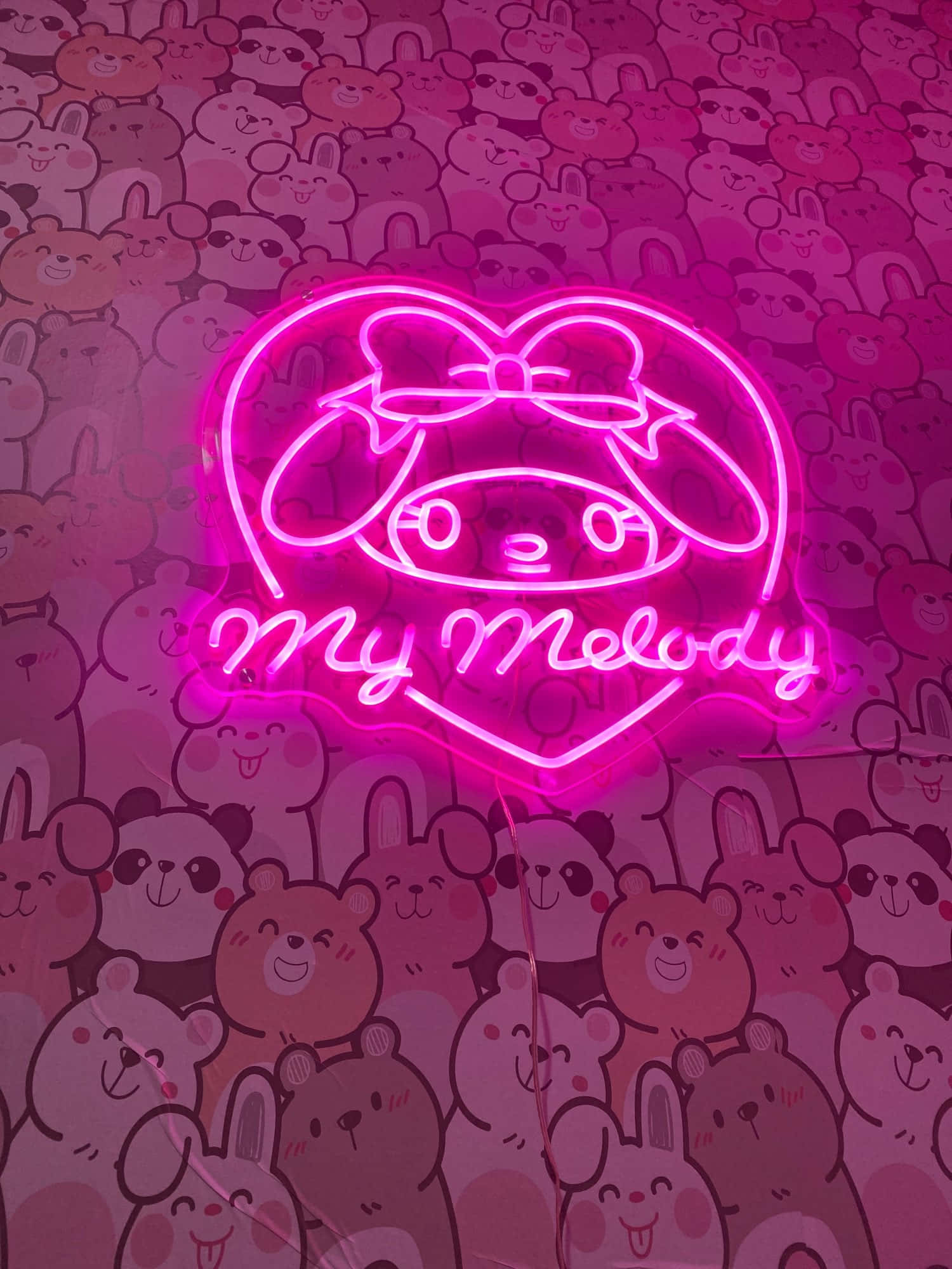 我的旋律 桌布 壁紙 — 一個發光粉紅色心形My Melody霓虹燈牌，背景牆上貼滿可愛卡通動物貼紙。