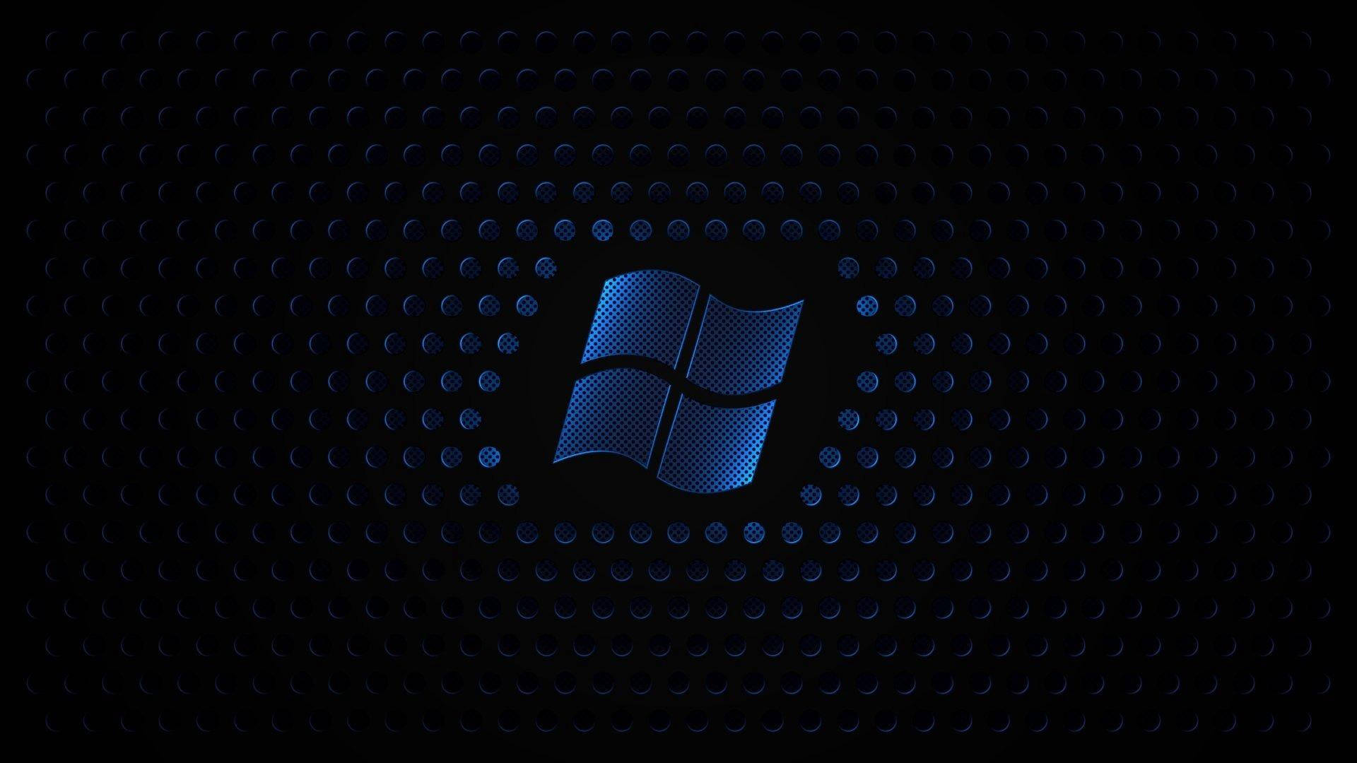 Dark Windows 桌布 壁紙 — 一個發光藍色Windows標誌置中於深色穿孔金屬紋理上，帶有微妙的光線反射。