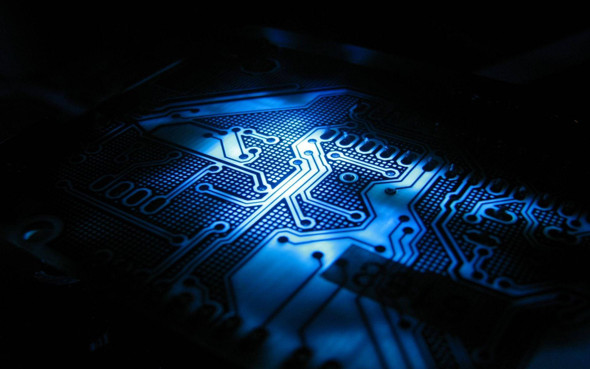 電力 桌布 壁紙 — 一個發光藍色電路板的特寫，在黑暗背景下被照亮。
