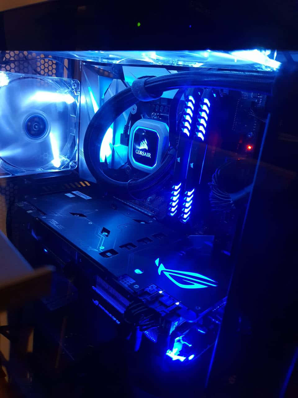 Cool Gaming 桌布 壁紙 — 一個發出藍光的電腦機箱，展示Corsair和ASUS ROG組件，帶有可見的風扇和液體冷卻。