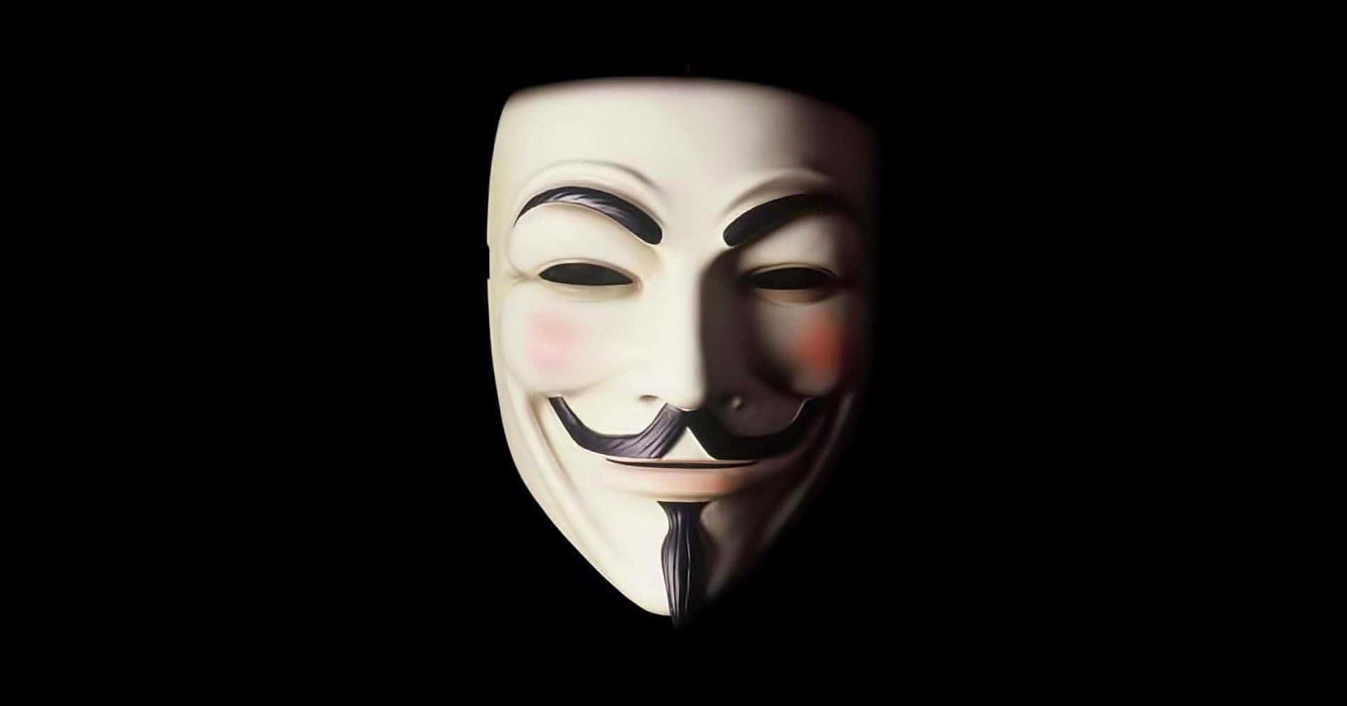 白色Guy Fawkes面具，玫瑰色臉頰和咧嘴笑，黑色背景。 — 匿名 GIF 壁紙