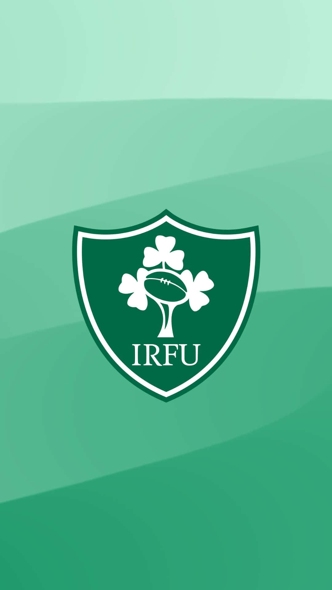 Ireland Rugby 桌布 壁紙 — 一個白色IRFU盾牌標誌，中央有一個三葉草和橄欖球，置於漸變綠色背景上。