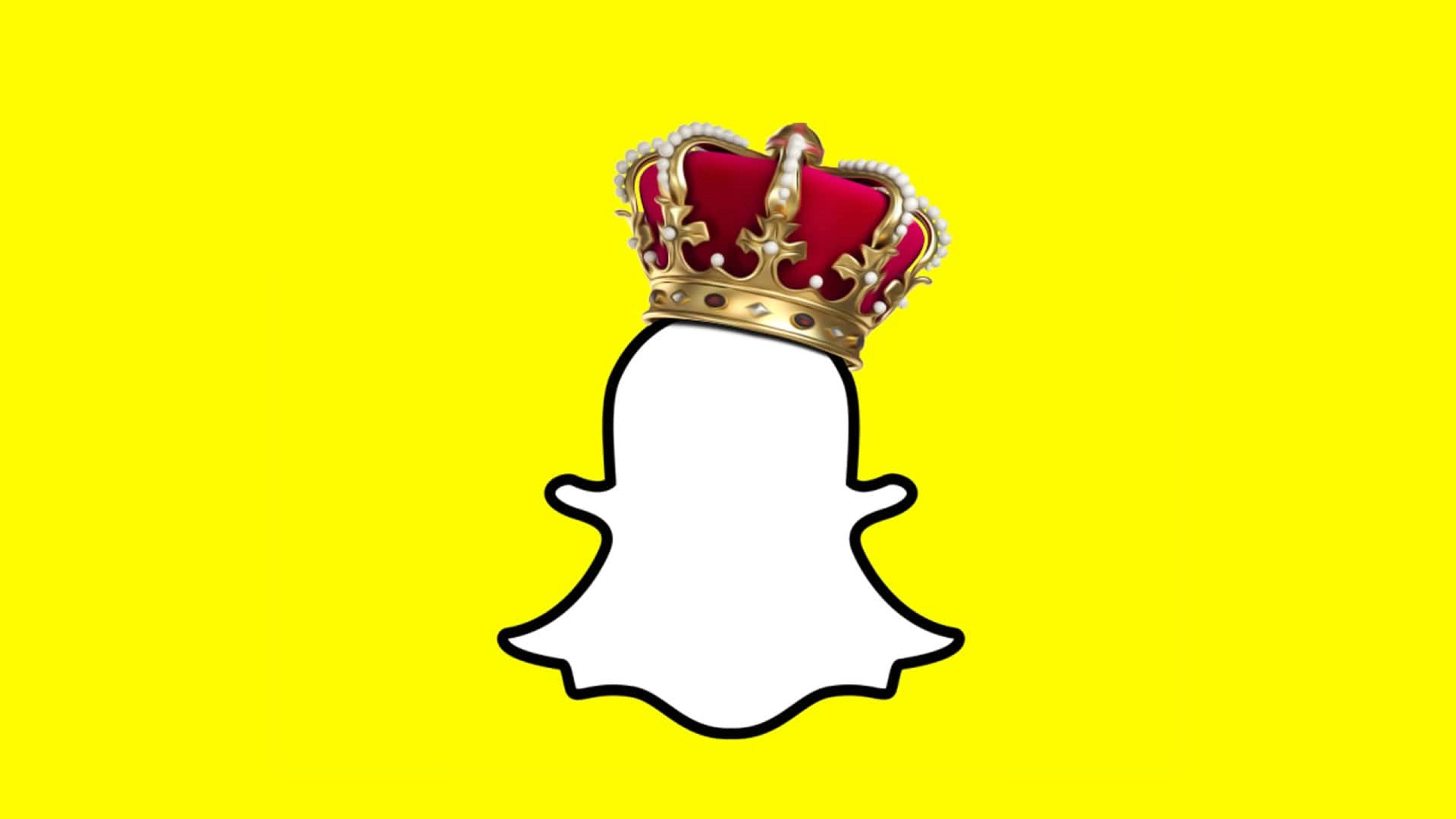 Snapchat 桌布 壁紙 — 一個白色Snapchat鬼魂標誌，戴著紅色天鵝絨和金色皇冠，背景為亮黃色。