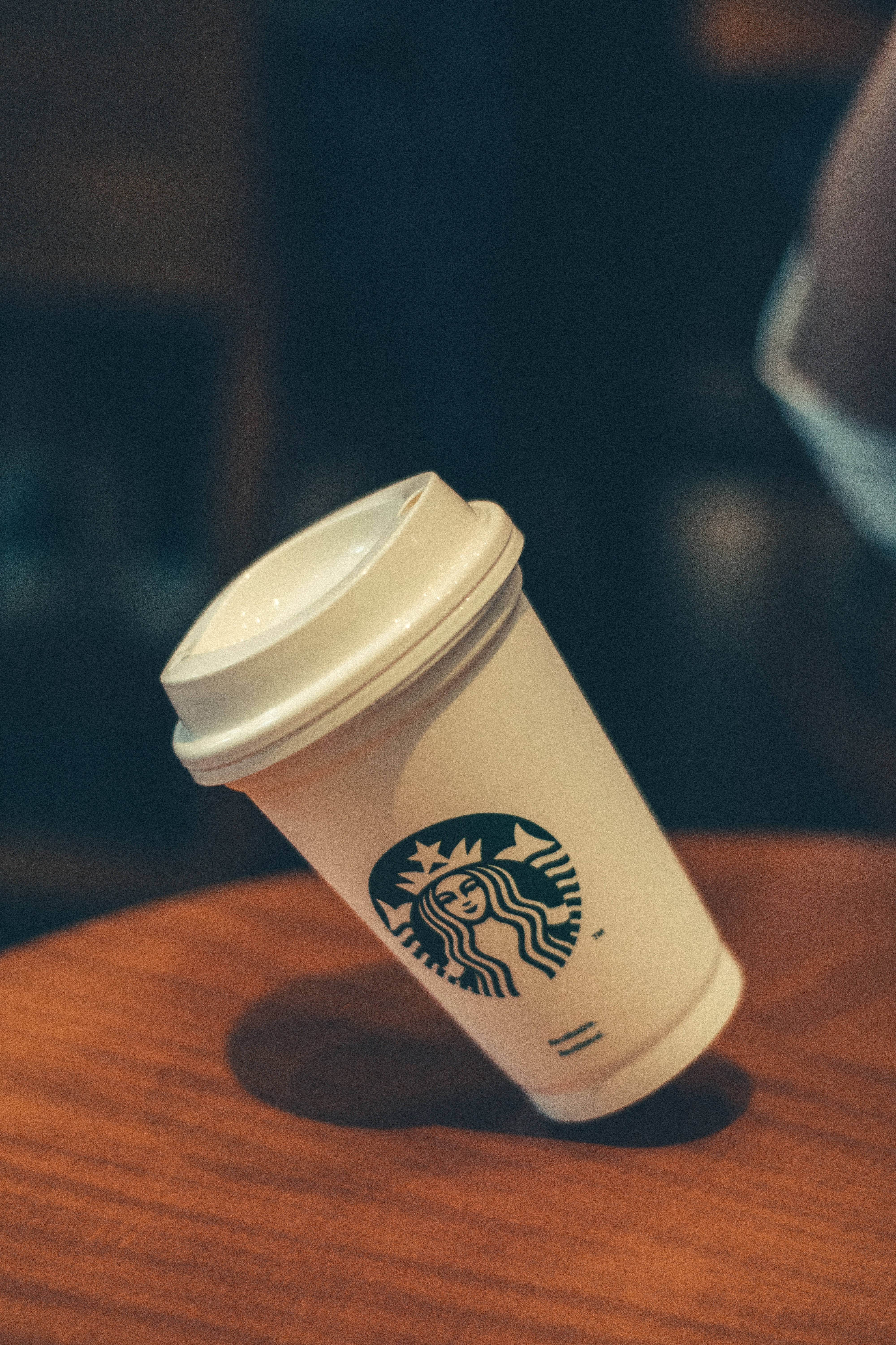 在舒適的咖啡店環境中，木桌上的一個Starbucks咖啡杯。 — 星巴克 GIF 壁紙