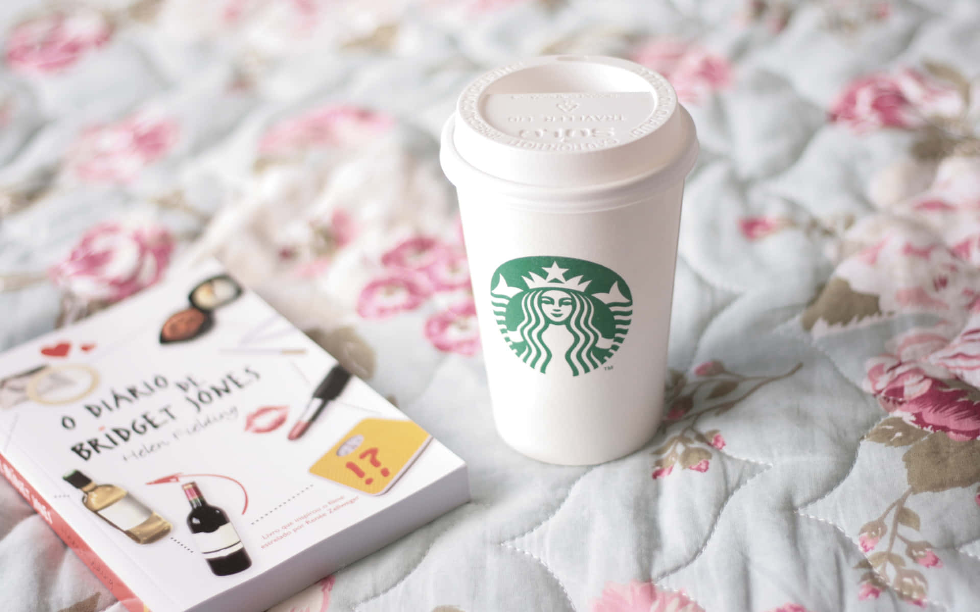 星巴克 桌布 壁紙 — 一個白色Starbucks杯和一本Bridget Jones書放在柔軟的花卉圖案絎縫床罩上。