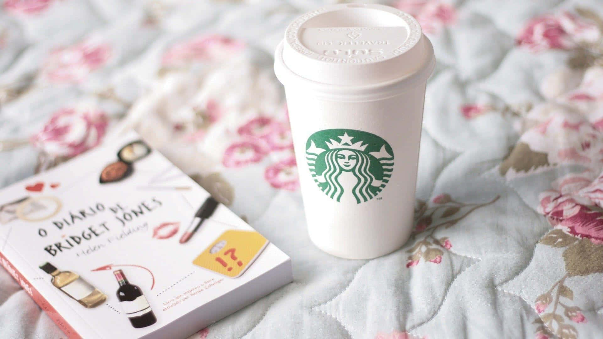 星巴克 桌布 壁紙 — 一個白色Starbucks杯和一本《BJ單身日記》書本放在一張花紋絎縫床罩上。