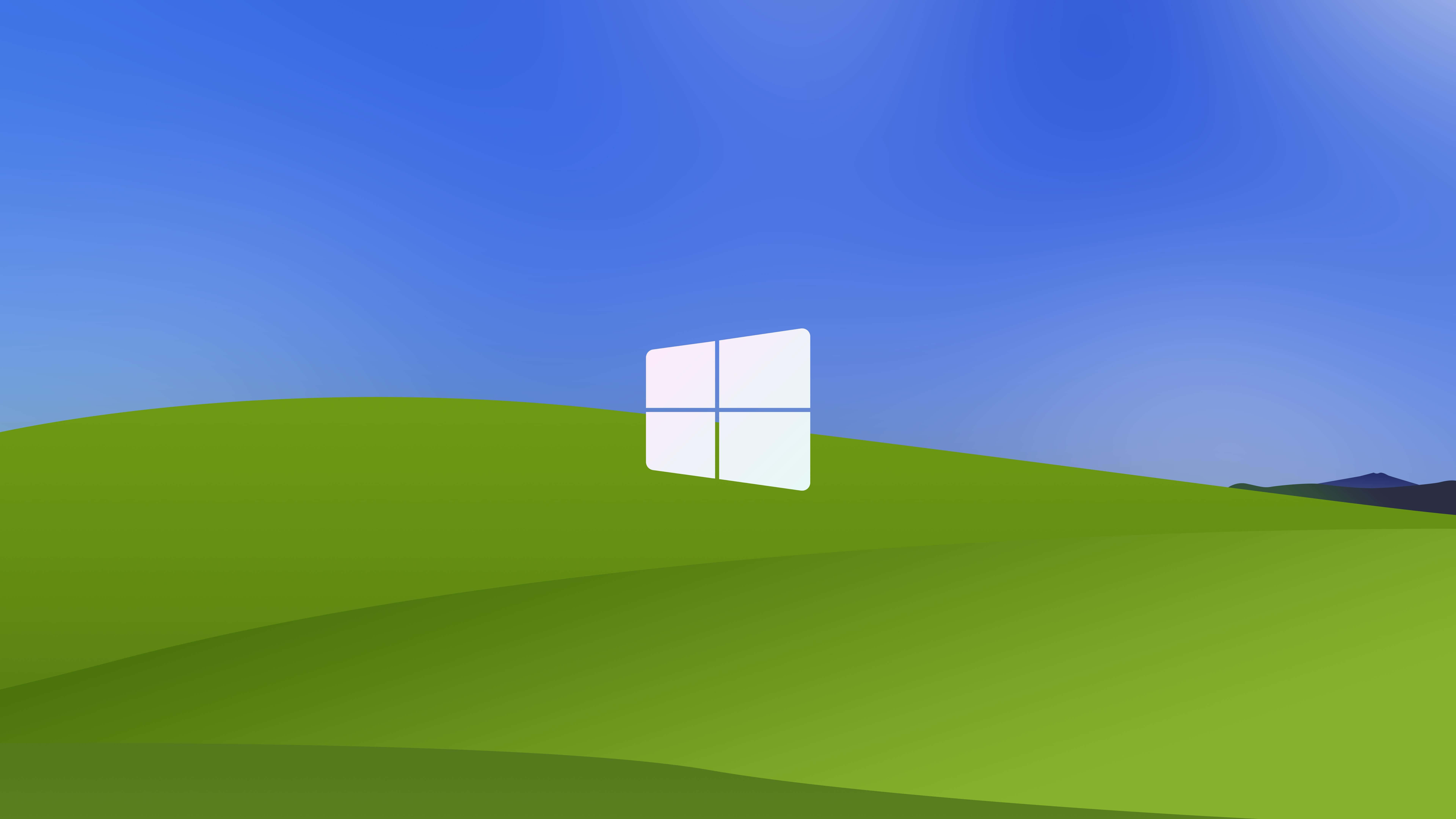 Windows Xp Logo 桌布 壁紙 — 一個白色Windows標誌放在起伏的綠色山丘上，天空清澈湛藍。