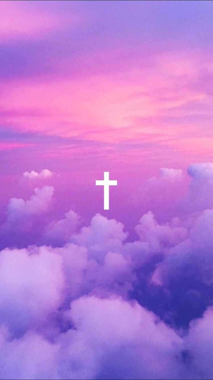 Cute Cross 桌布 壁紙 — 一個白色十字架在夢幻般的粉紅色和紫色天空下，平靜地漂浮在蓬鬆的雲層之上。