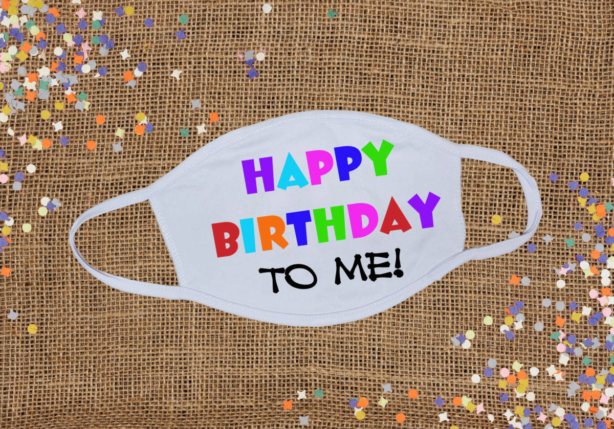 Me 桌布 壁紙 — 一個白色口罩上印有彩虹色 'HAPPY BIRTHDAY TO ME!' 文字，放在麻布上，周圍環繞著彩色星形紙屑。