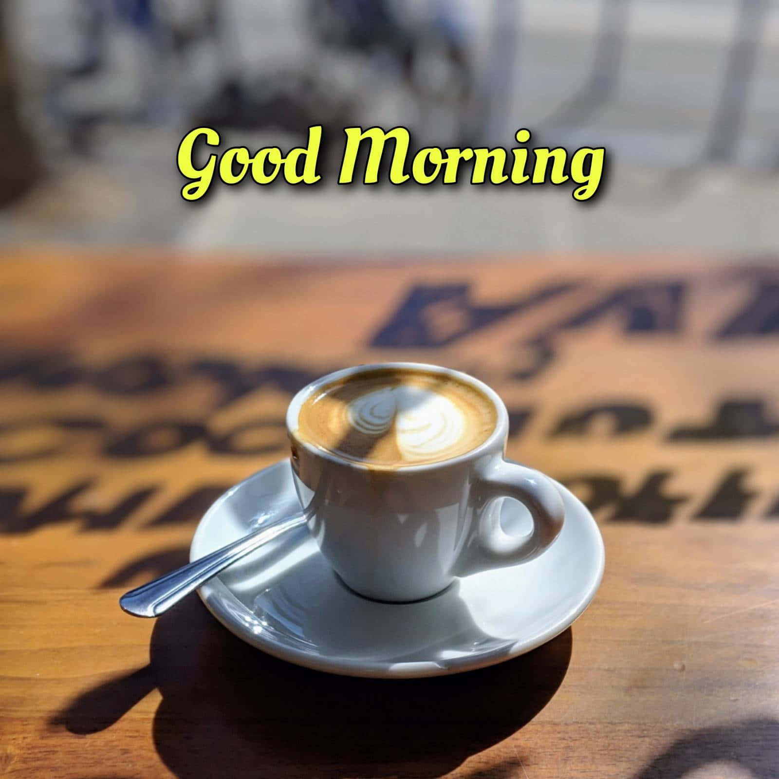 Coffee 桌布 壁紙 — 一個白色咖啡杯帶有拉花藝術，放在木桌上，晨光投射出字母的影子。