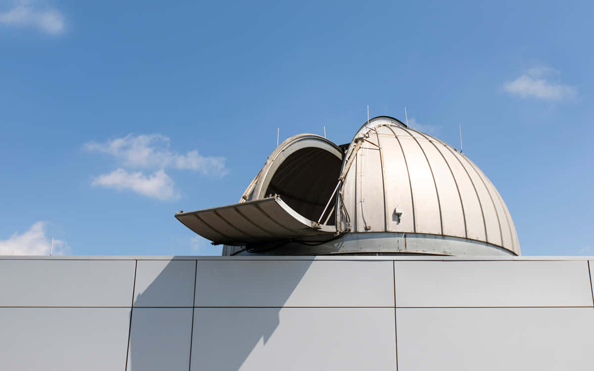 Observatory 桌布 壁紙 — 一個白色天文台圓頂，屋頂打開，襯托著晴朗的藍天和散落的雲朵。