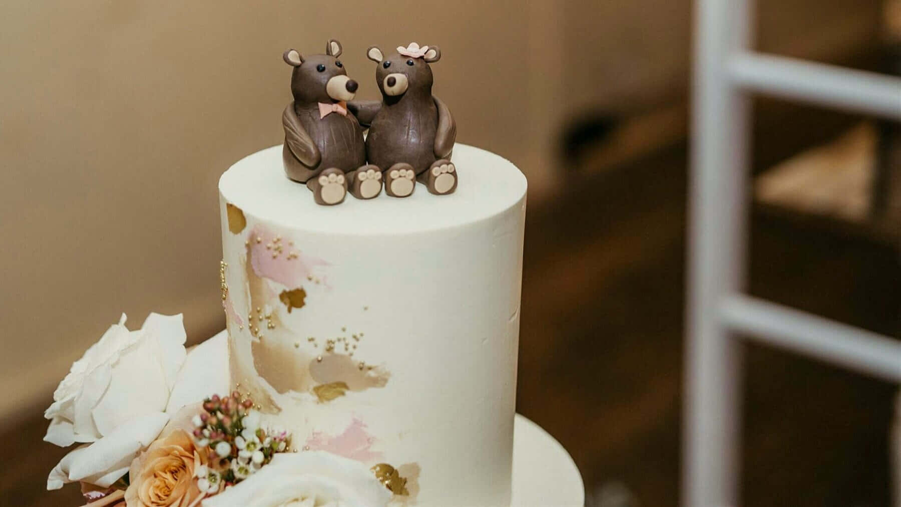 Cake Fondant 桌布 壁紙 — 一個白色婚禮蛋糕，飾有金色和粉紅色水彩潑濺，頂部有兩隻手牽手的巧克力熊公仔。