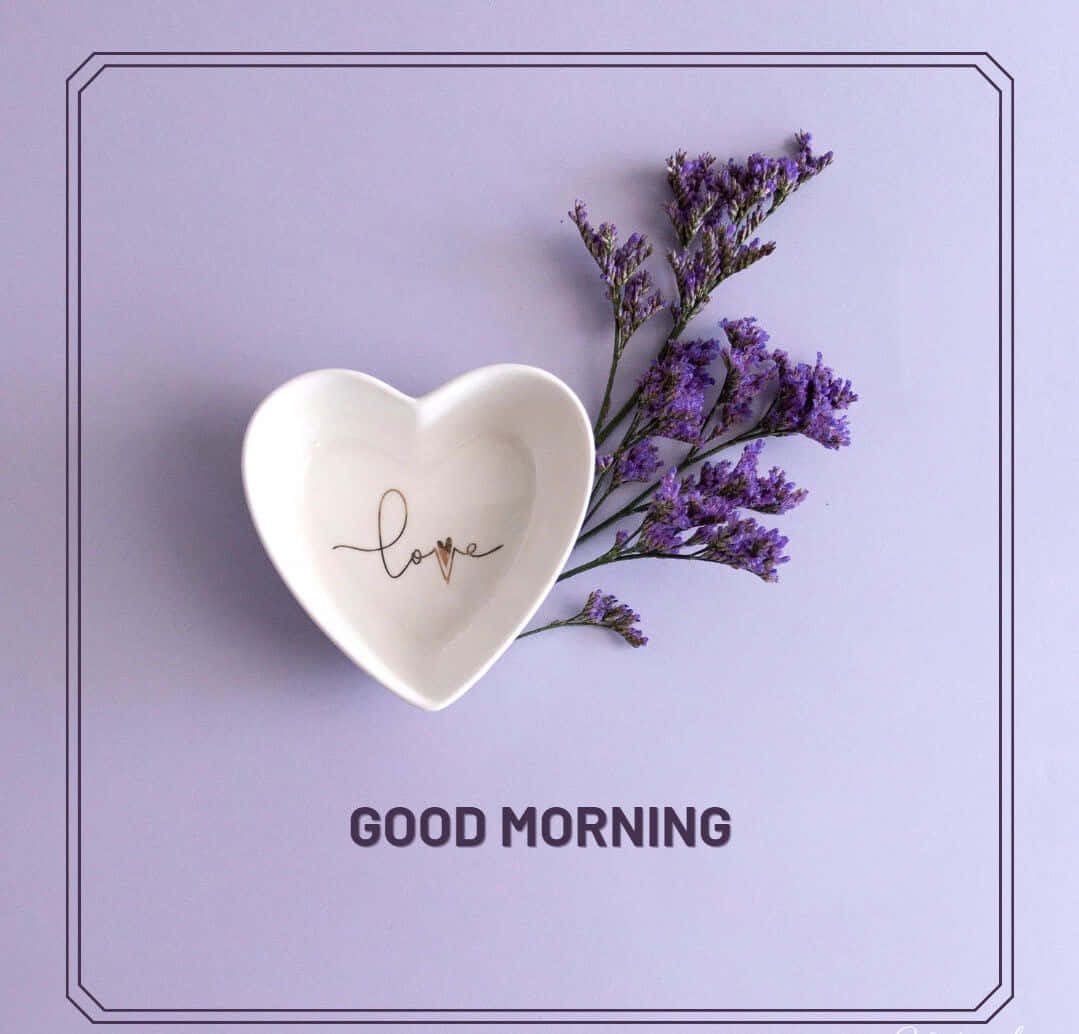  壁紙 — 一個白色心形盤子，裡面寫著love，旁邊放著紫色乾燥花，背景是柔和的薰衣草色。