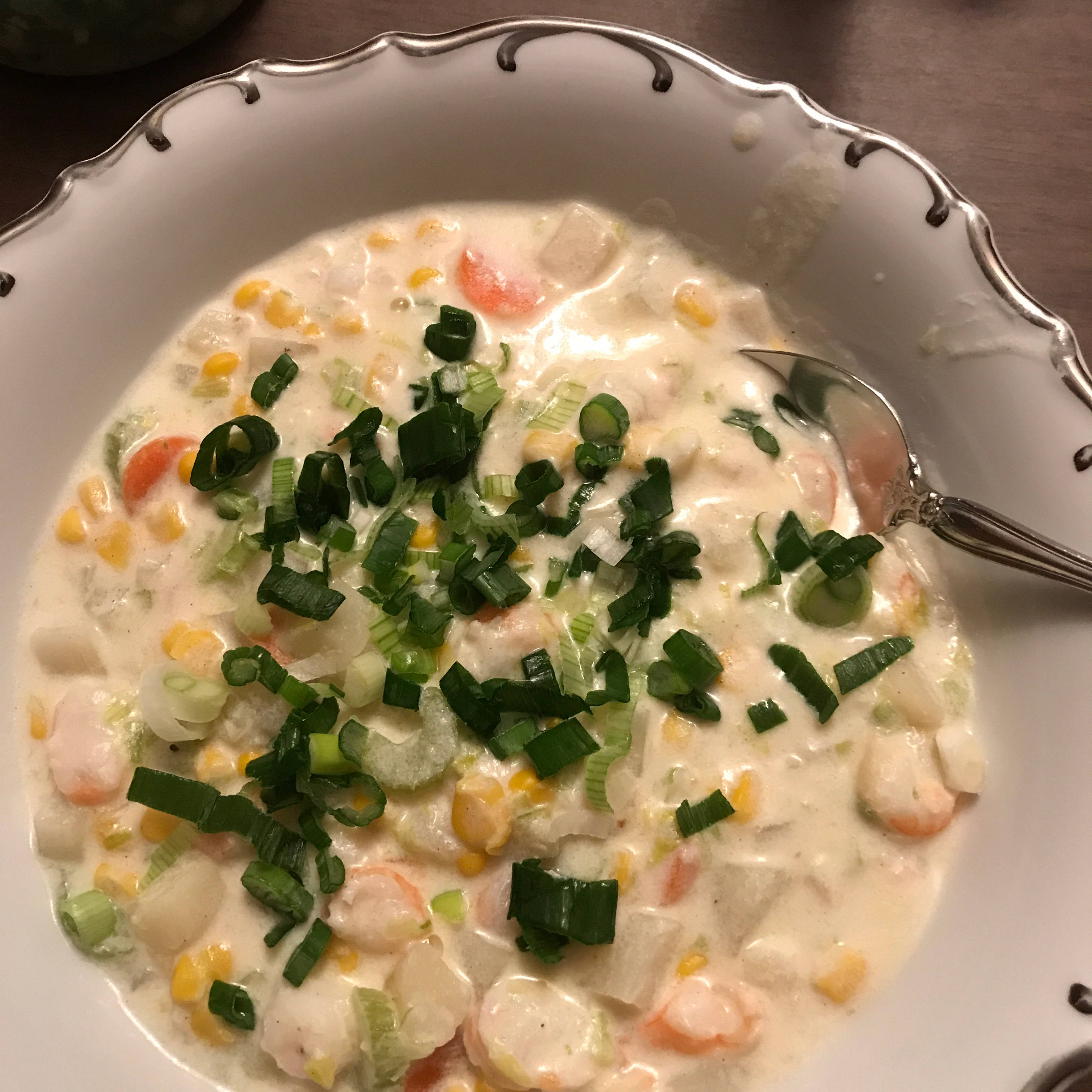 Chowder 桌布 壁紙 — 一個白色扇貝形碗中的奶油海鮮濃湯，上面撒上新鮮青蔥，湯匙浸在濃郁的湯汁中。