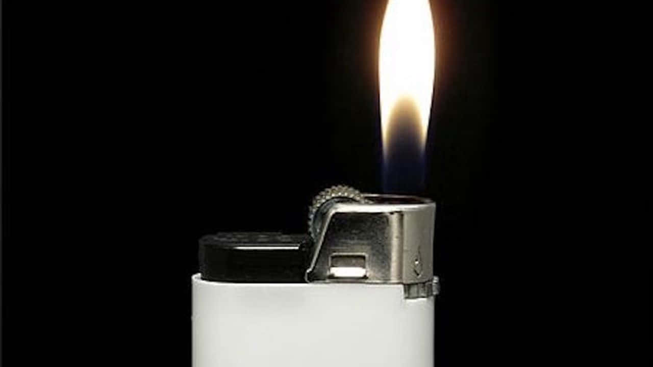 lighter 桌布 壁紙 — 一個白色打火機，帶有藍色和黃色火焰，在純黑色背景上明亮地燃燒。