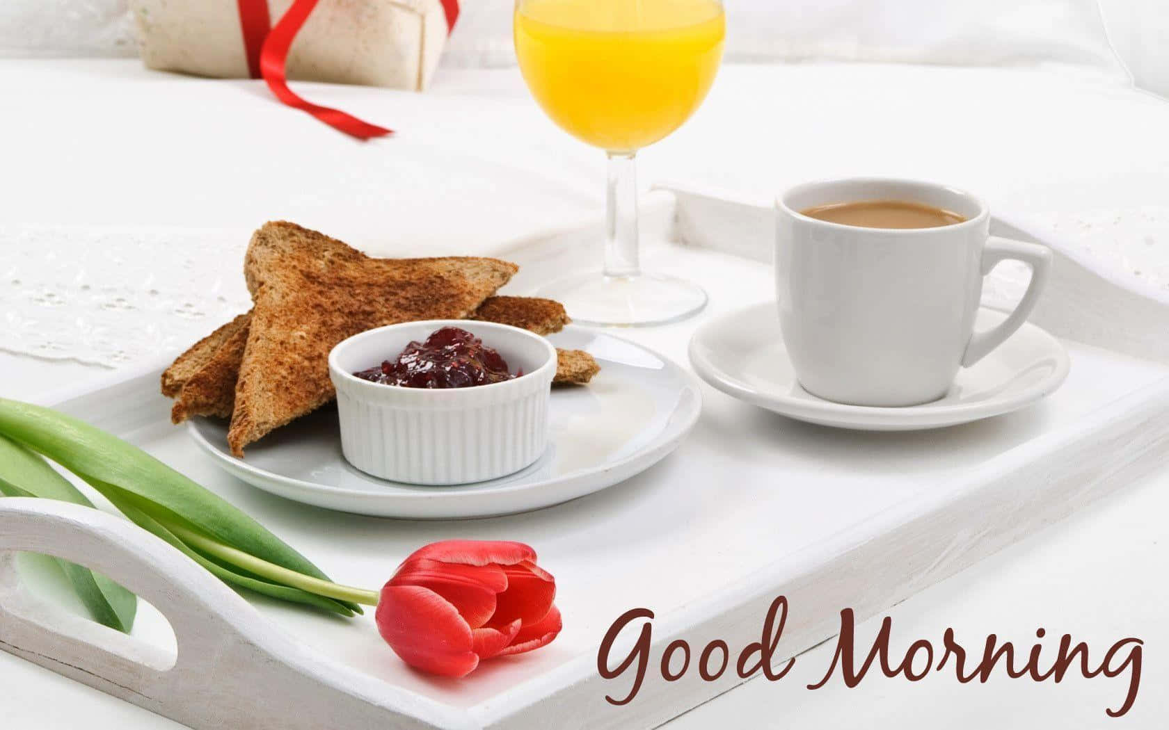 Good Morning 桌布 壁紙 — 一個白色托盤上放有吐司、果醬、咖啡和柳橙汁，旁邊有一朵紅色鬱金香和一份用紅絲帶包裝的禮物。