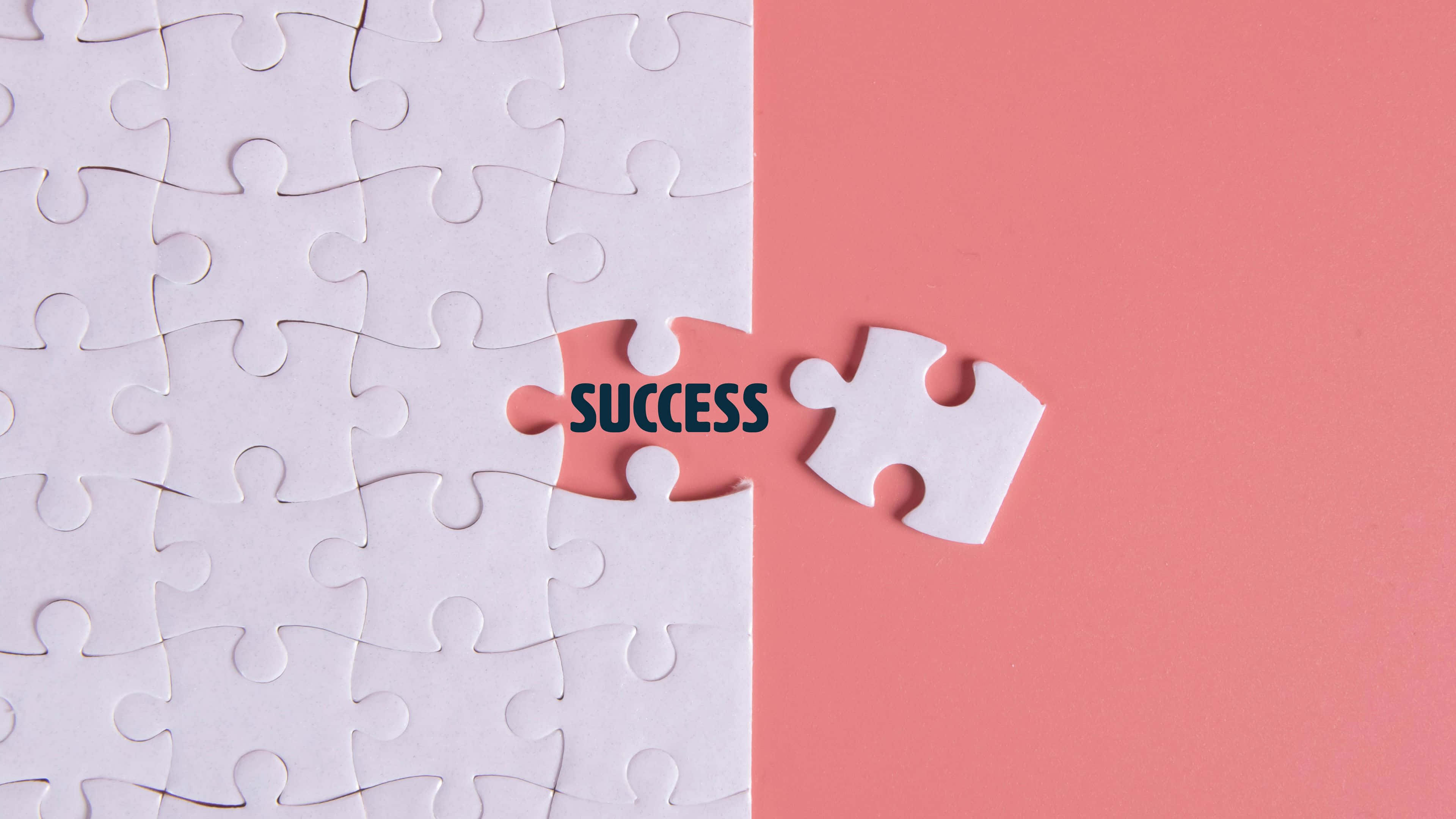 Puzzle 桌布 壁紙 — 一個白色拼圖，缺少一塊，在粉紅色背景上顯現出「成功」一詞。