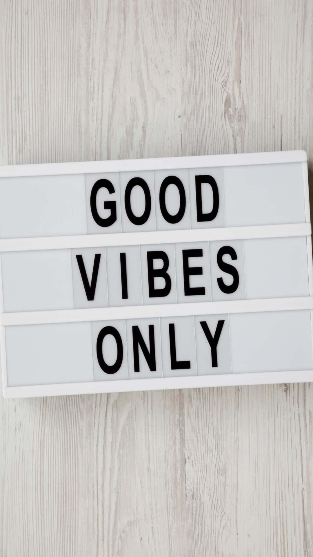 sign 桌布 壁紙 — 一個白色燈箱以粗體黑色字母顯示「GOOD VIBES ONLY」，放置在淺色木質表面上。
