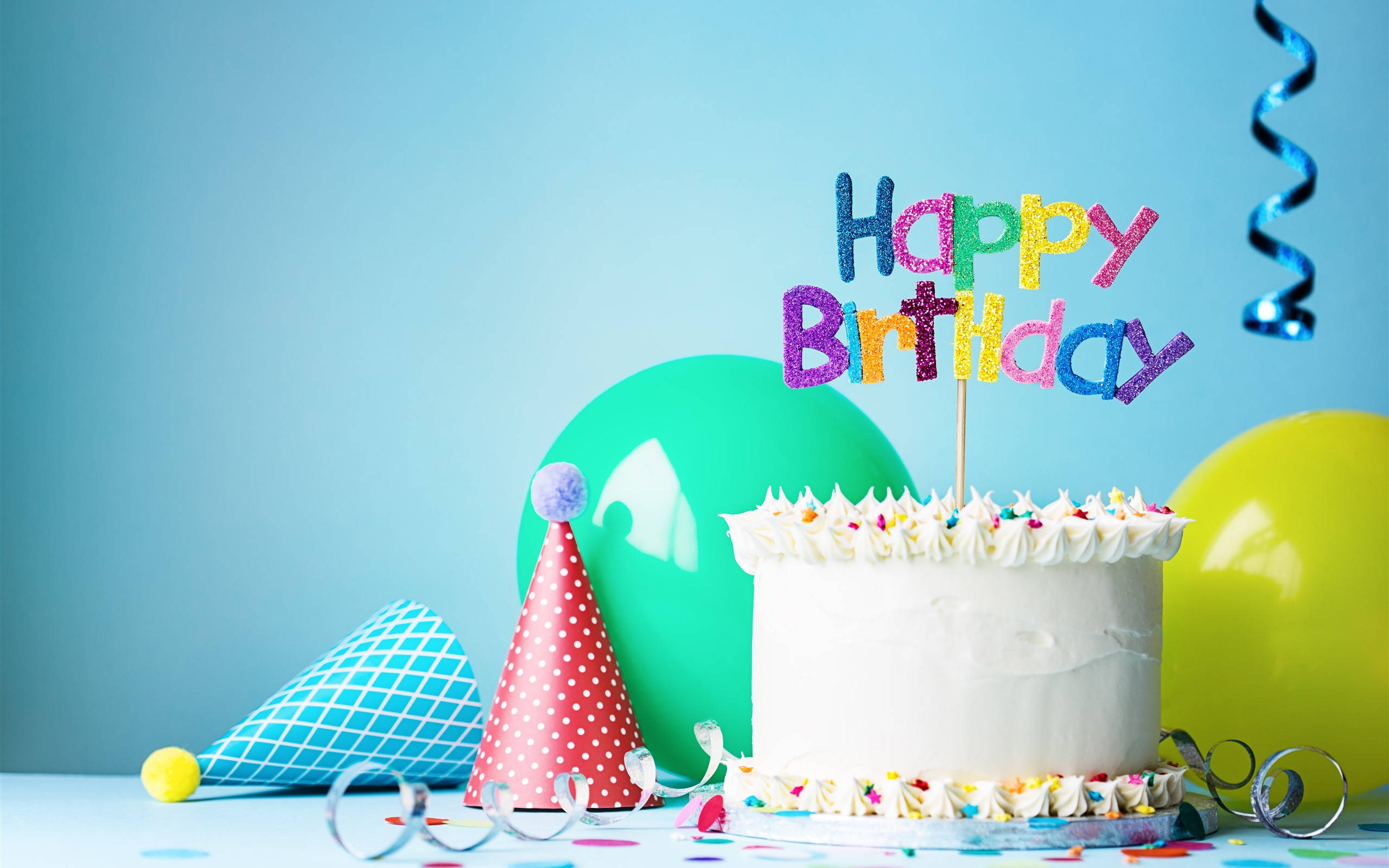 my 桌布 壁紙 — 一個白色生日蛋糕，上面有彩色糖粒和閃亮的「Happy Birthday」裝飾，旁邊有派對帽和氣球，背景為藍色。