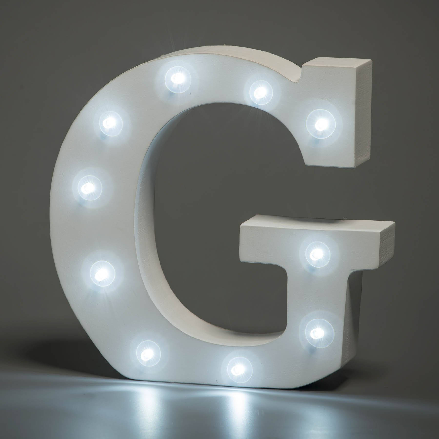 g 桌布 壁紙 — 一個白色發光字母G，帶有發光燈泡，立在深灰色背景的反射表面上。