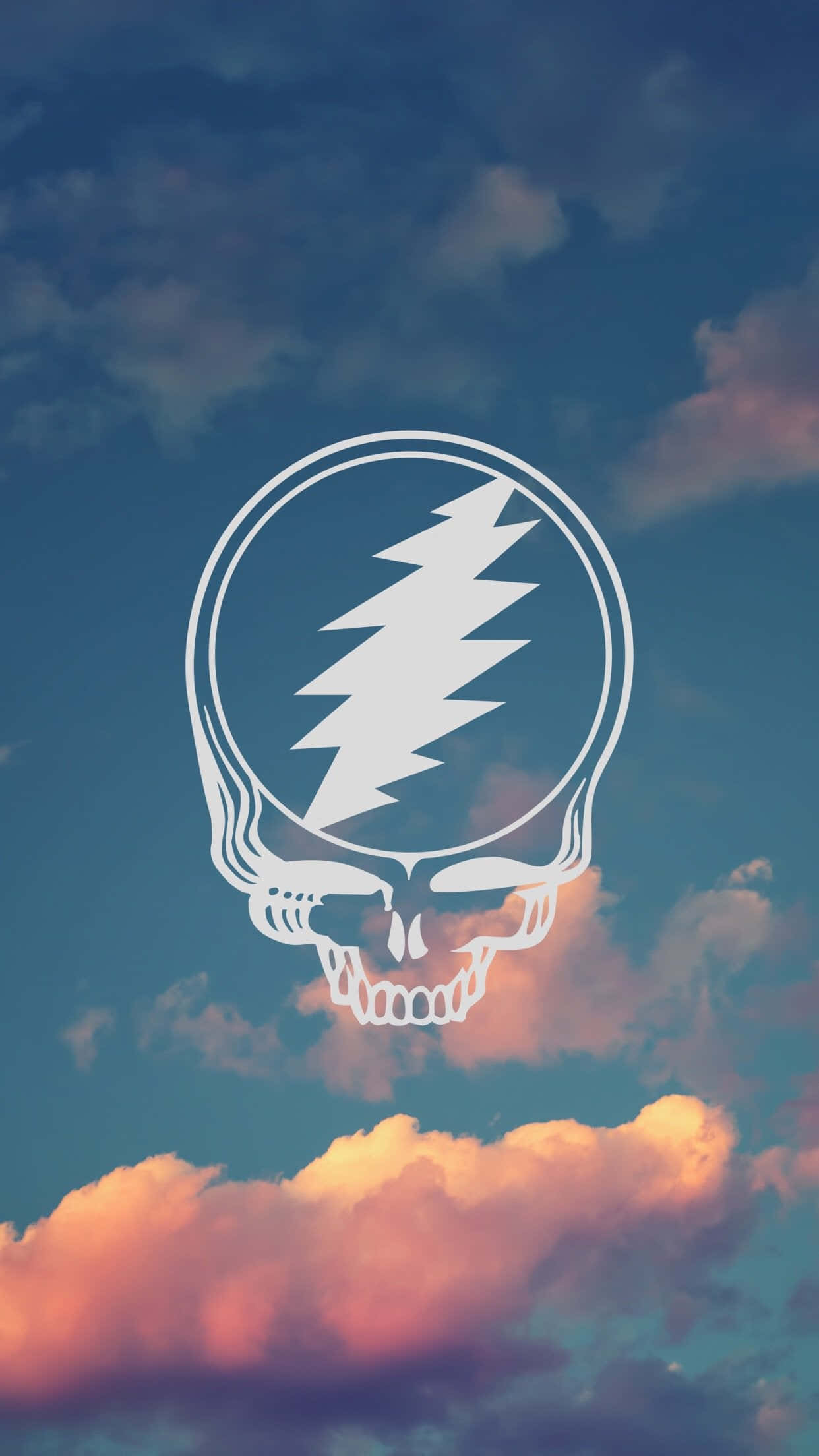 Grateful Dead iPhone 桌布 壁紙 — 一個白色的Grateful Dead骷髏標誌在帶有粉紅色和藍色雲彩的暮色天空中漂浮。