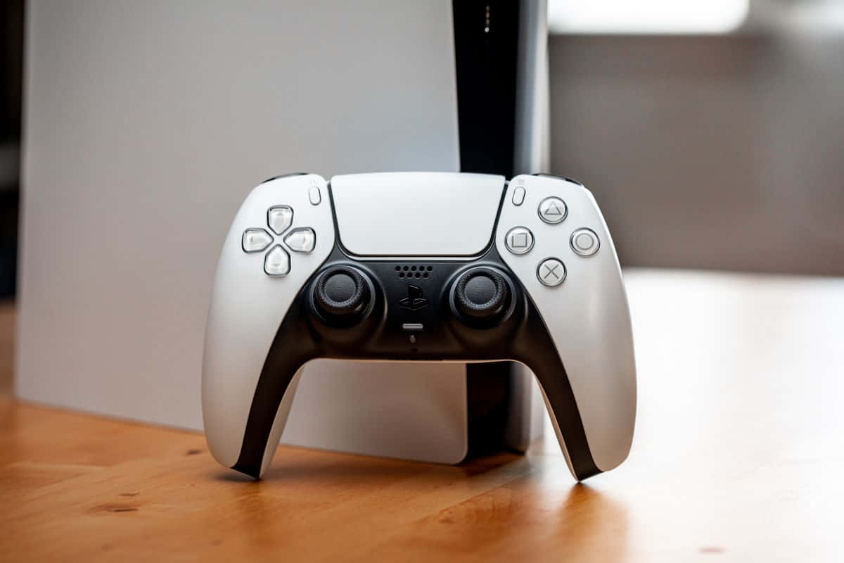 PS5 動態圖片 桌布 壁紙 — 一個白色的PlayStation 5 DualSense控制器放在木質表面上，旁邊是其主機，在一個柔和光線的房間裡。
