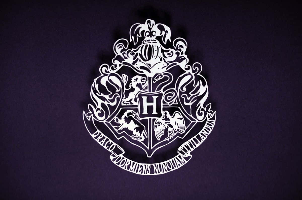 Hogwarts Crest 桌布 壁紙 — 一個白色的霍格華茲學校徽章在深紫色背景上脫穎而出，帶有精緻細節和一個大膽的中央 'H'。