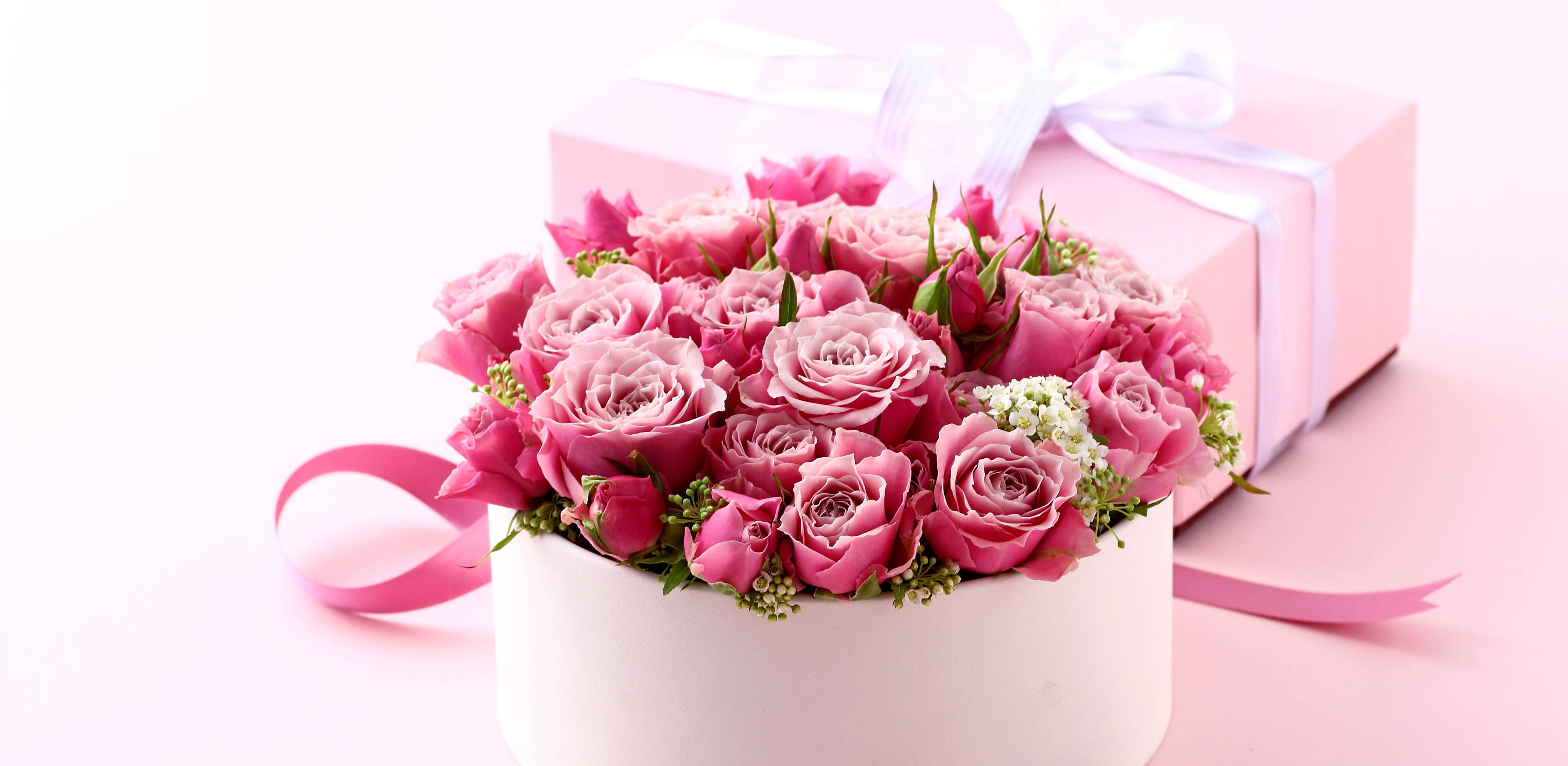 Happy Birthday Flowers 桌布 壁紙 — 一個白色盒子裡擺放著茂盛的粉紅玫瑰，旁邊是一個搭配的粉紅色禮物盒，繫著白色絲帶。