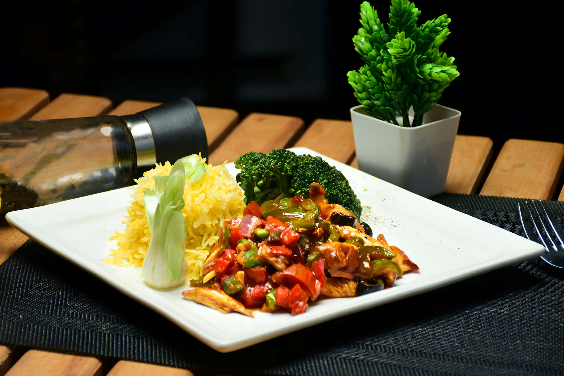 Chicken Chilli Dry with rice on a plate 壁紙 — 一個白色盤子上，有色彩繽紛的雞肉、甜椒和青花菜炒菜，配上黃飯。