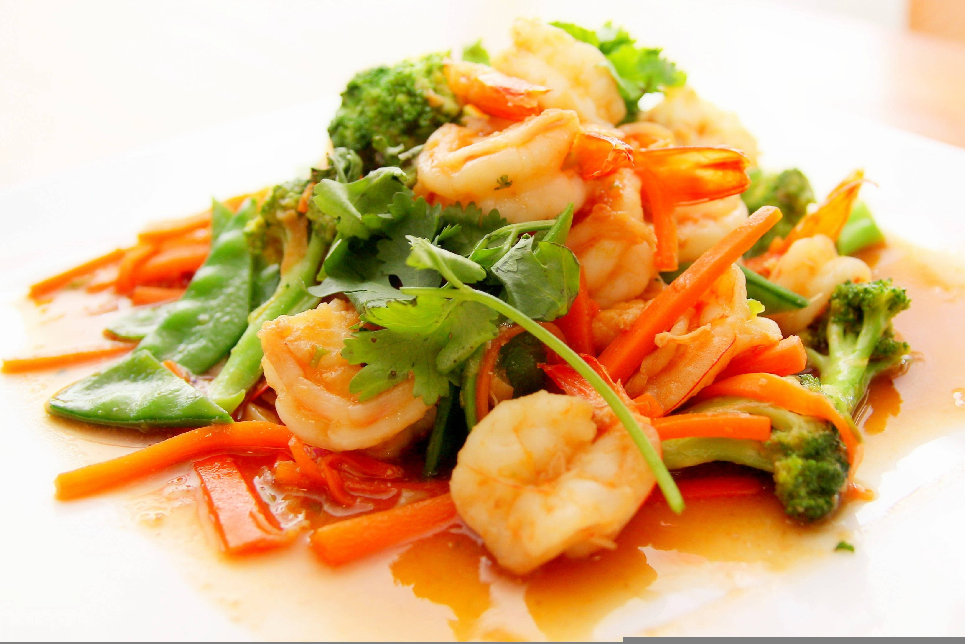 Vegetables 桌布 壁紙 — 一個白色盤子上，有鮮嫩蝦仁、青花菜、荷蘭豆和紅蘿蔔的鮮豔炒菜，配上新鮮香菜作裝飾。