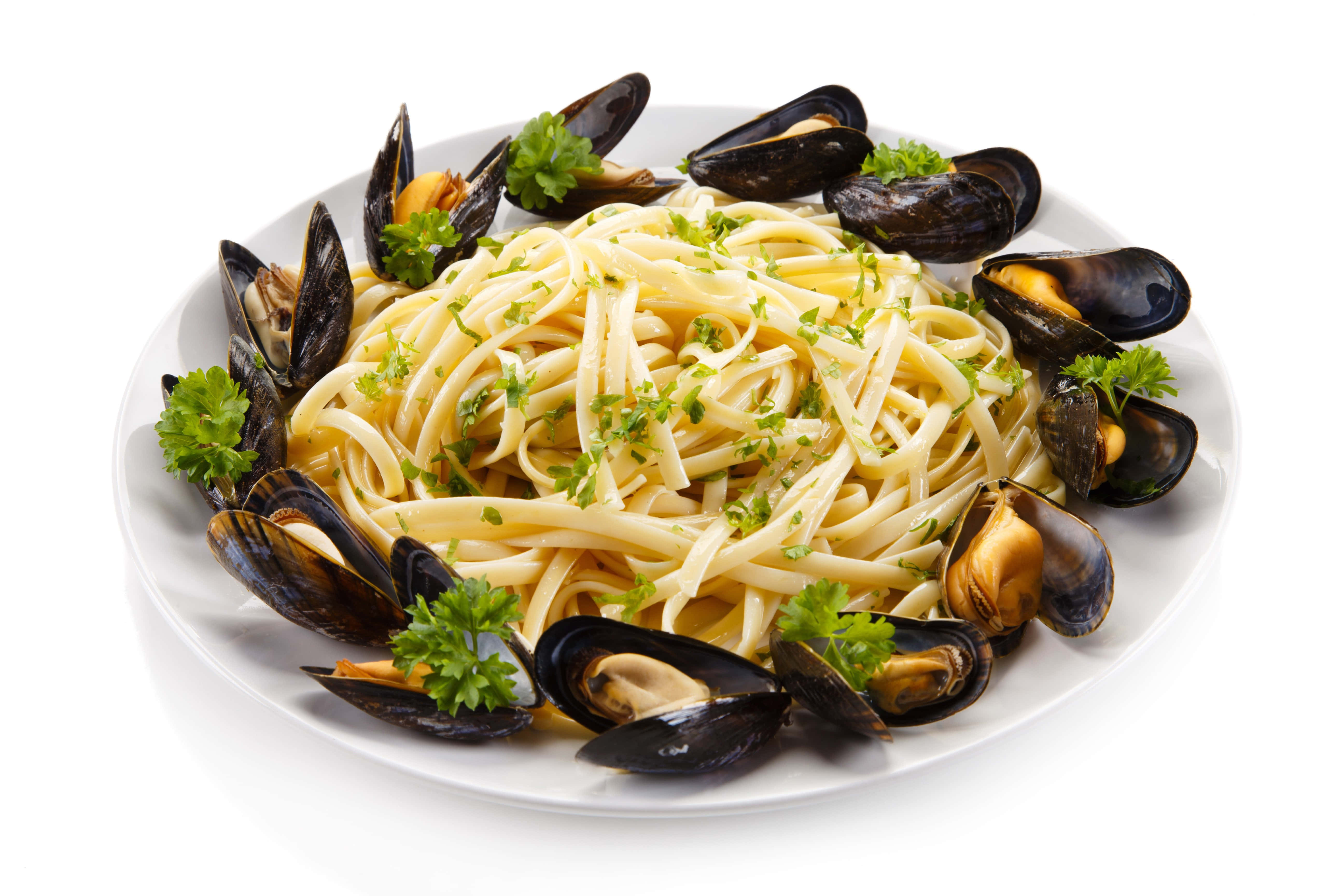 4K Pasta 桌布 壁紙 — 一個白色盤子上放著奶油義大利麵，上面撒上新鮮巴西里，周圍環繞著打開的淡菜，淡菜肉呈金黃色。