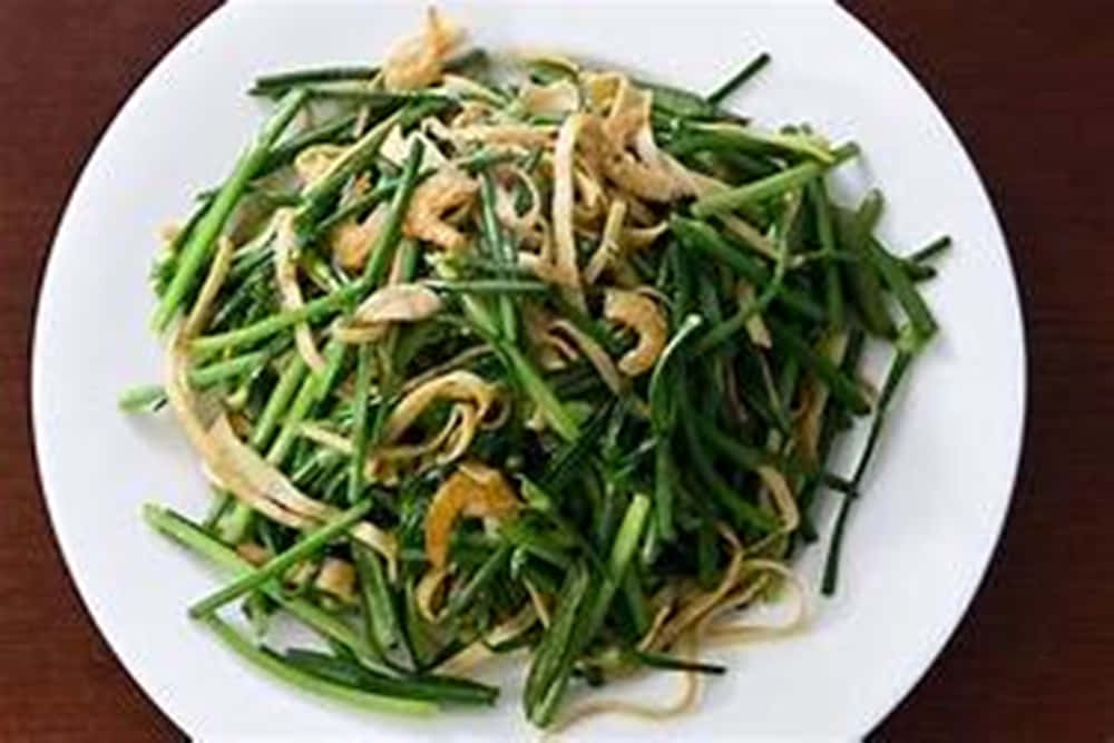 Food Photography 桌布 壁紙 — 一個白色盤子盛載著色彩鮮豔的炒青蔥和金黃色炸豆腐條，放在深色木桌上。