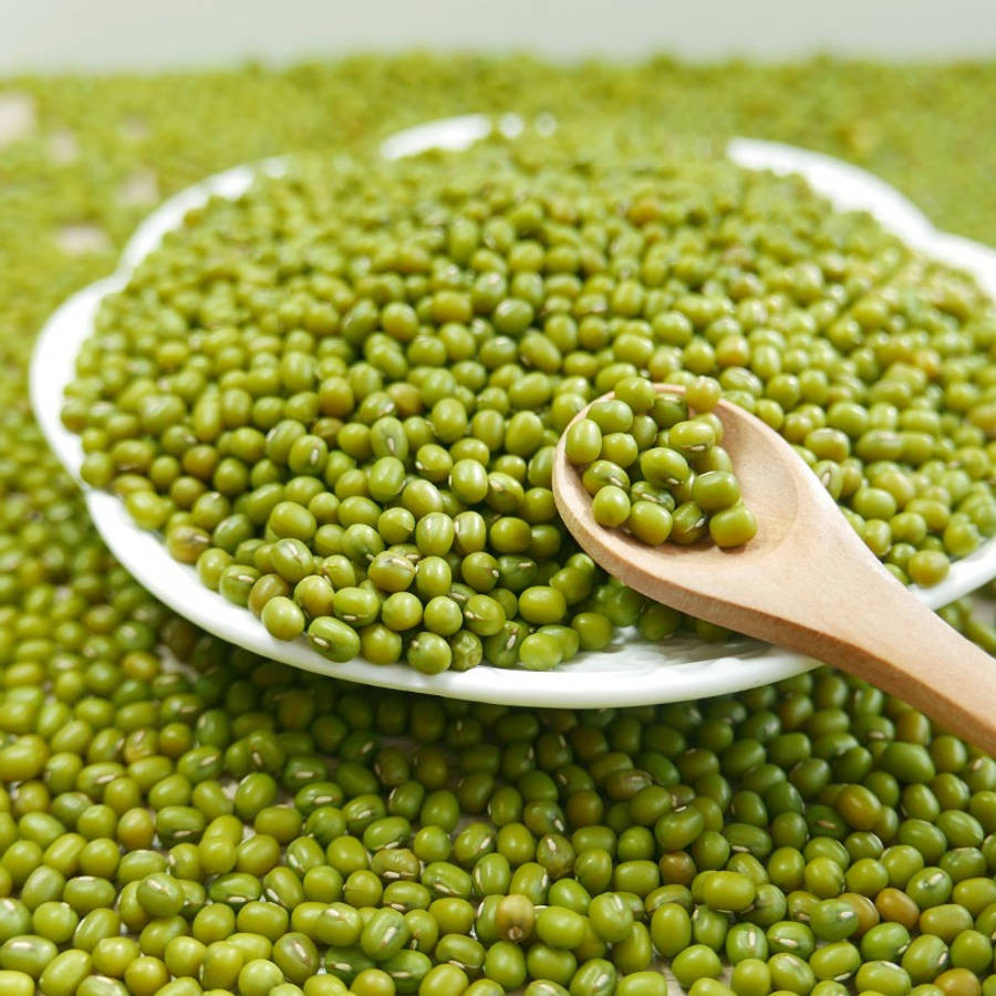 beans 桌布 壁紙 — 一個白色盤子裝滿鮮綠色綠豆，木匙舀起一些豆子，背景是模糊的綠色。