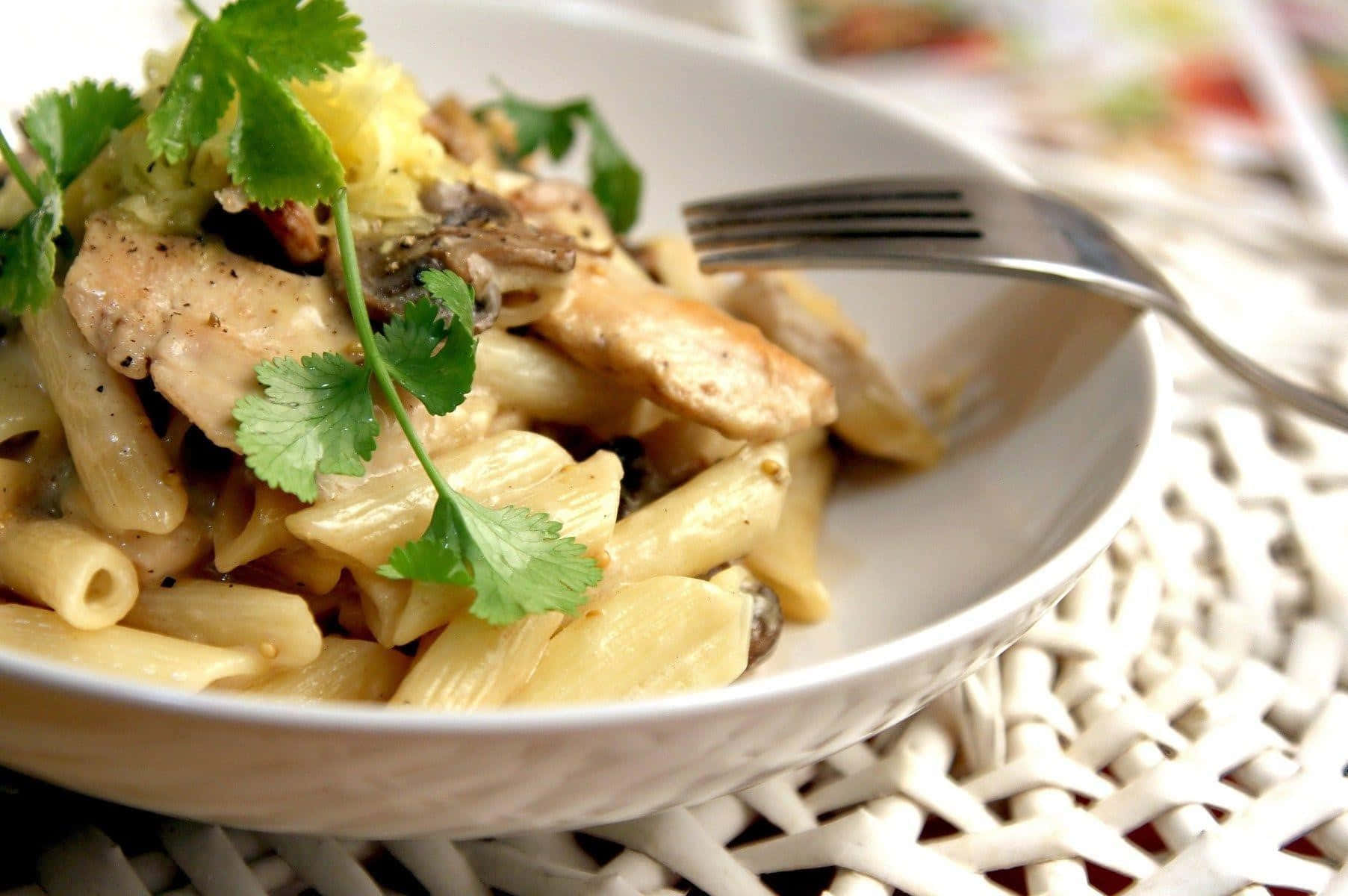 Pasta 桌布 壁紙 — 一個白色碗中的奶油雞肉蘑菇義大利麵，上面飾以新鮮香菜的特寫。