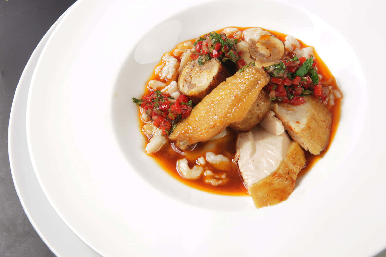 Chicken 桌布 壁紙 — 一個白色碗盛載著煎封雞肉塊，配上濃郁的紅色醬汁，上面放上新鮮綠色香草和紅甜椒粒。