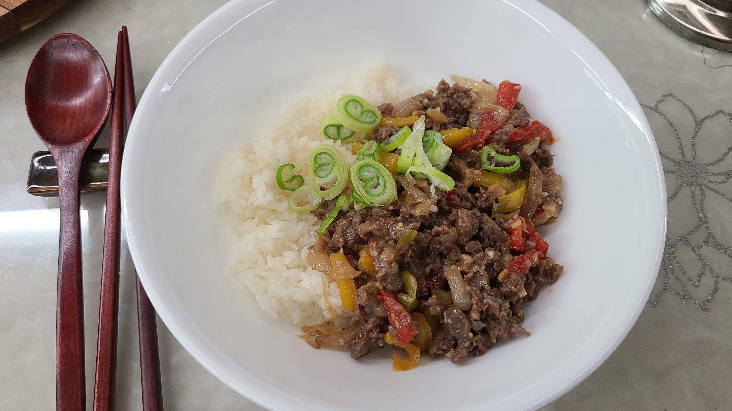 肉 桌布 壁紙 — 一個白色碗盛載蒸米飯，上面放有美味的牛肉和色彩繽紛的甜椒，並以切片青蔥作裝飾。