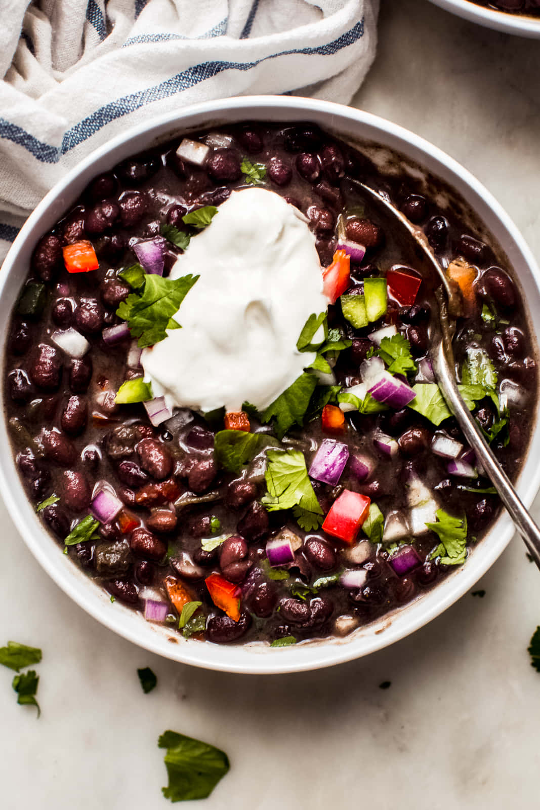 Black Bean Soup 桌布 壁紙 — 一個白色碗裝滿黑豆，上面放有酸奶油、香菜和切丁蔬菜。