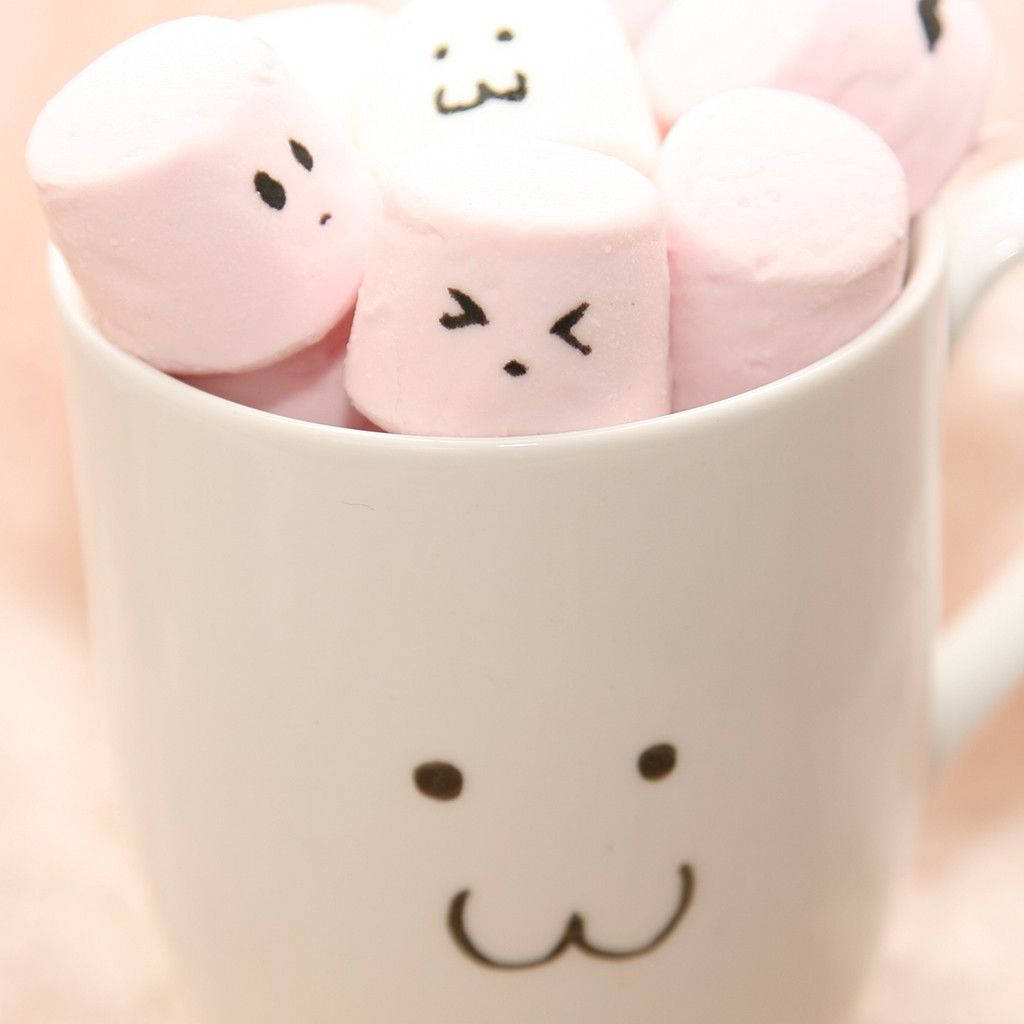 Marshmallow 桌布 壁紙 — 一個白色笑臉馬克杯裝著粉紅色棉花糖，上面畫有可愛的黑色臉孔。