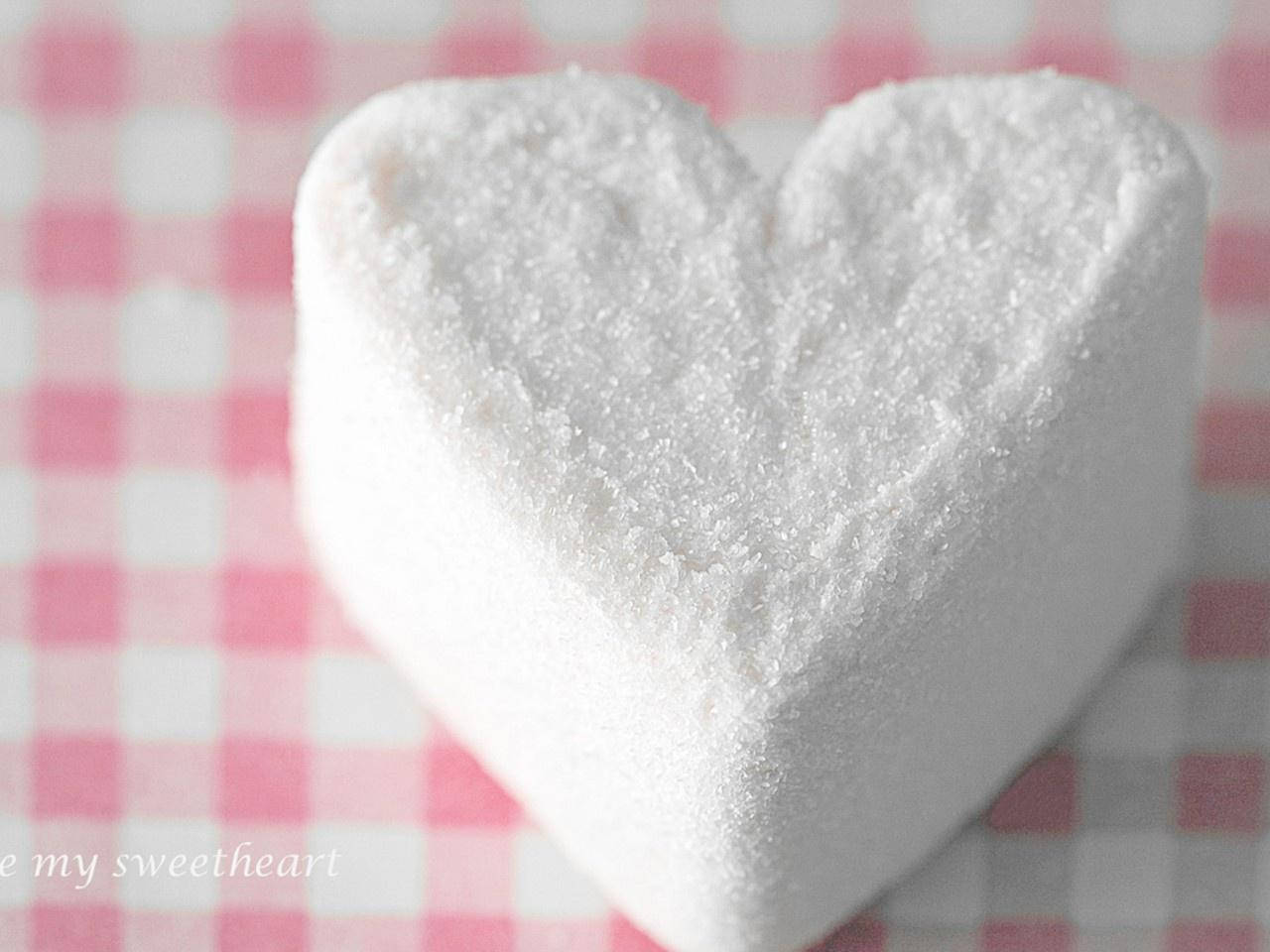 Marshmallow 桌布 壁紙 — 一個白色糖心心形放在粉紅和白色格子表面上的特寫。