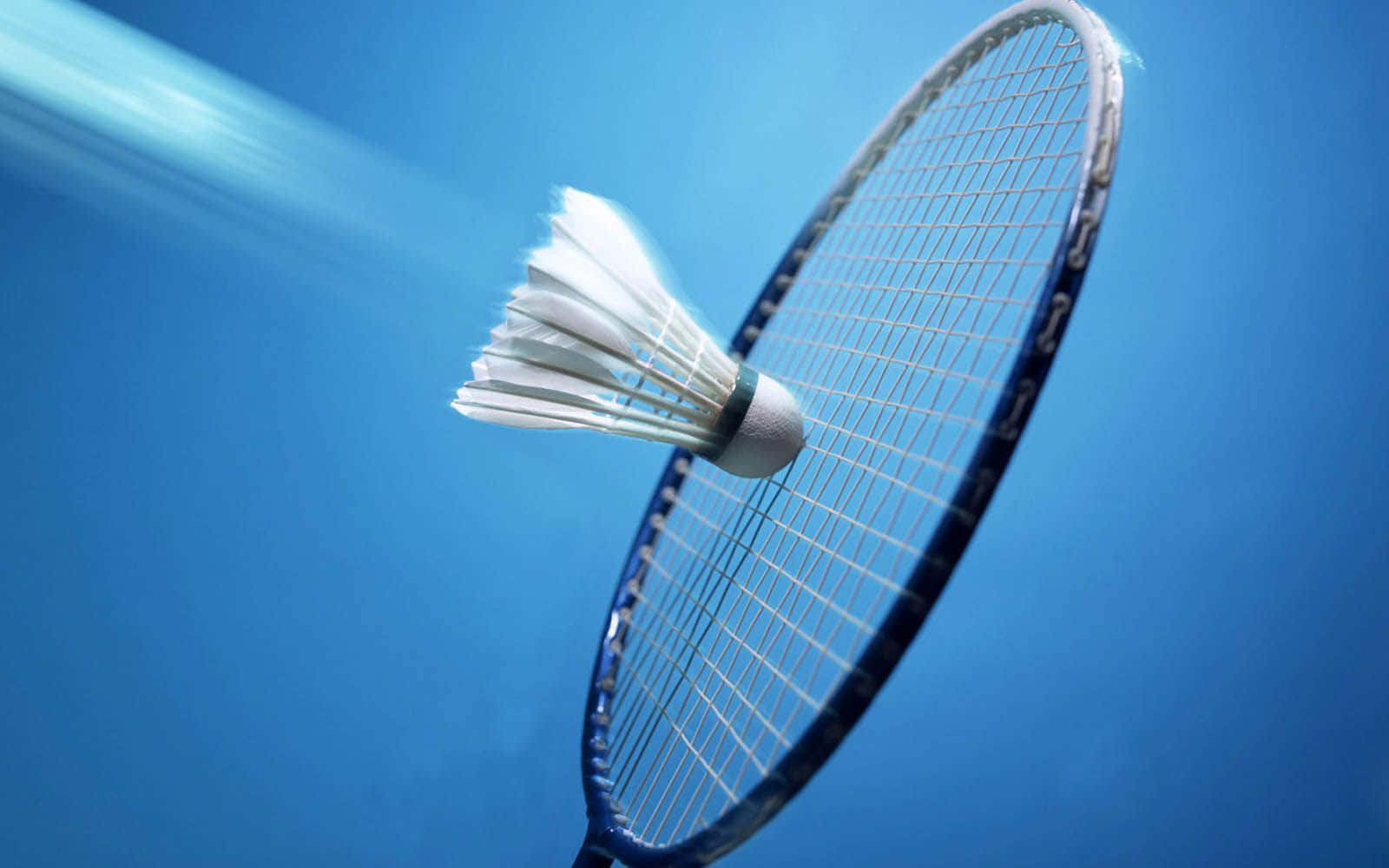 HD Badminton 桌布 壁紙 — 一個白色羽毛球擊中藍色羽毛球拍，背景是充滿活力的藍天，帶有動態模糊效果。