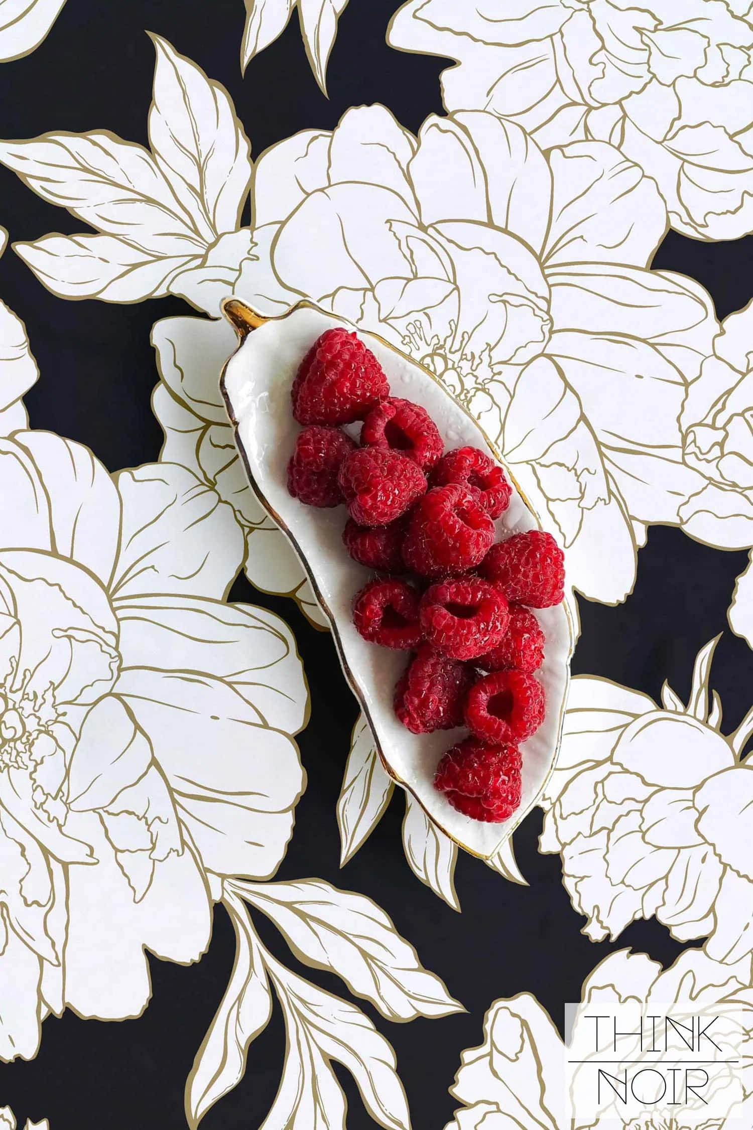 Raspberry 桌布 壁紙 — 一個白色葉形盤子盛裝飽滿的紅覆盆子，背景為黑色，並有優雅的白色和金色花卉輪廓。